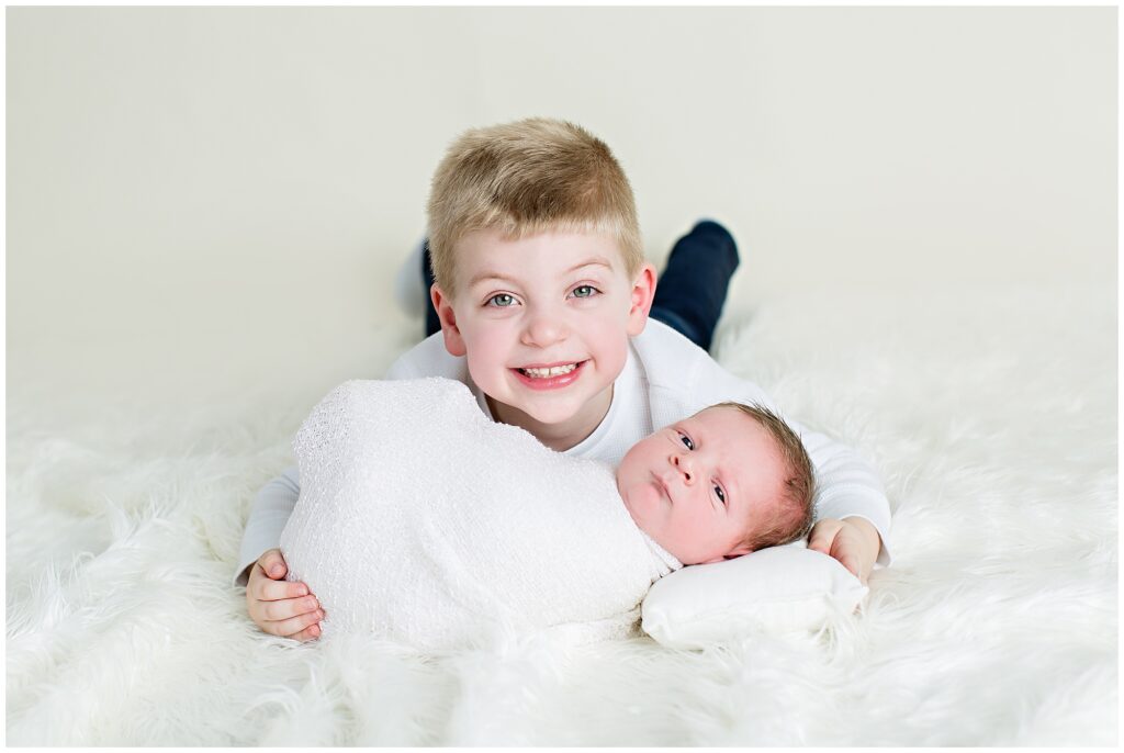 Newborn Wrap Pose with Older Brother | CB Studio, LLC Iowa Photographer | White wrap and cream background