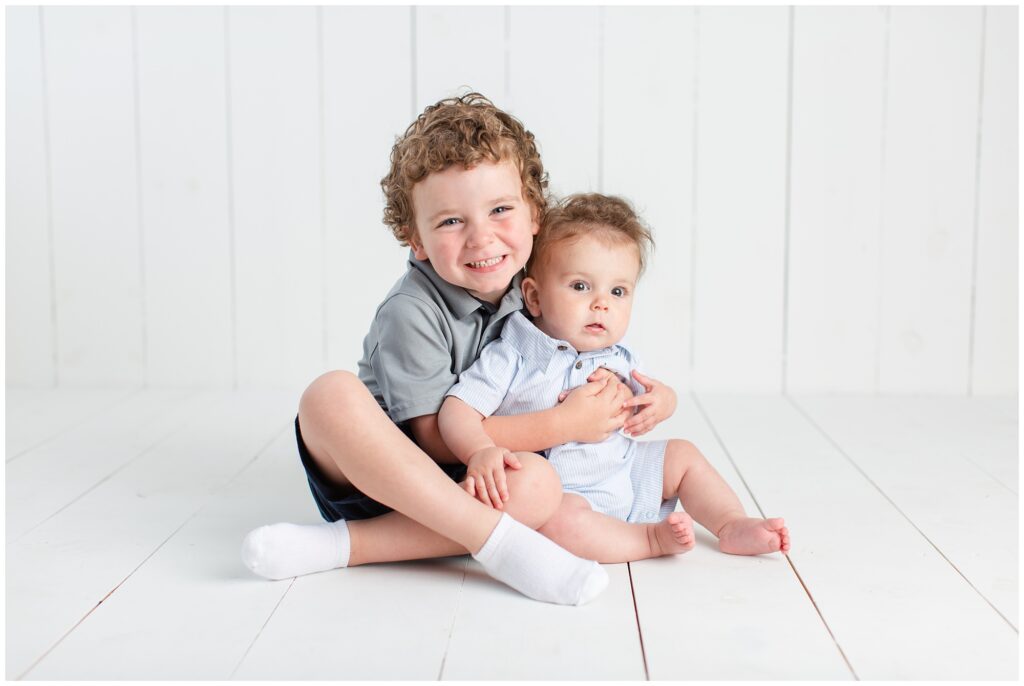 Brothers on a white wood background | Iowa Children Photographer | CB Studio