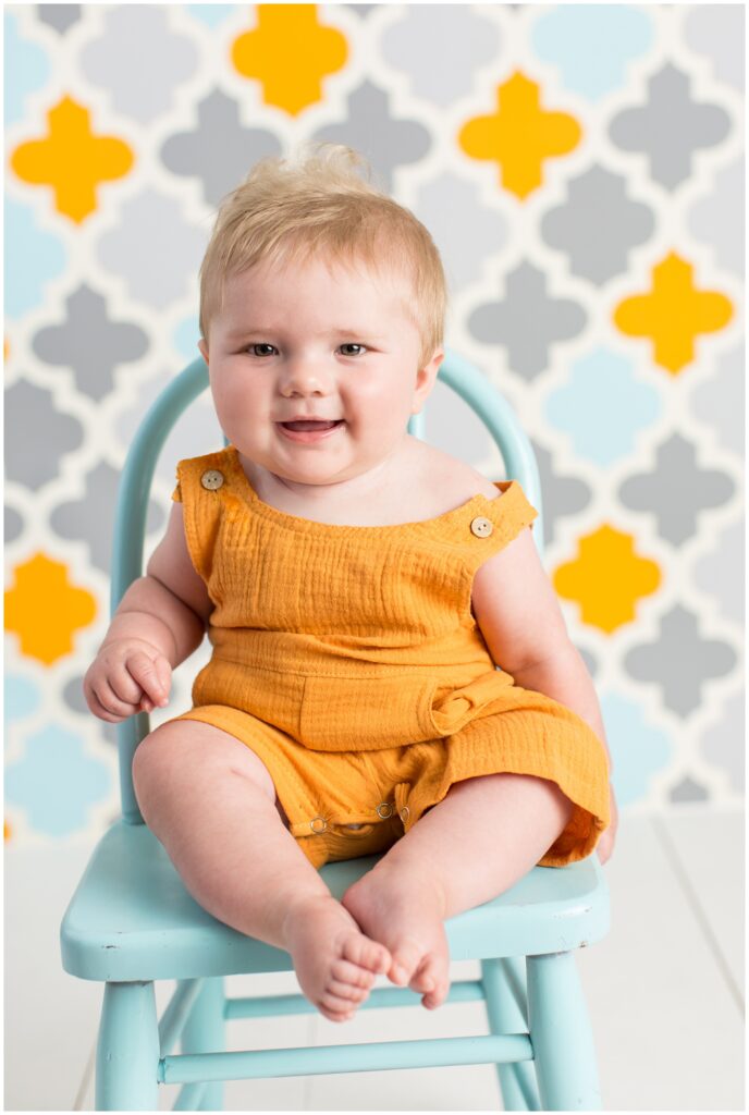 Sitter Session | Baby boy in orange romper and blue chair | Iowa Baby Photographer | CB Studio