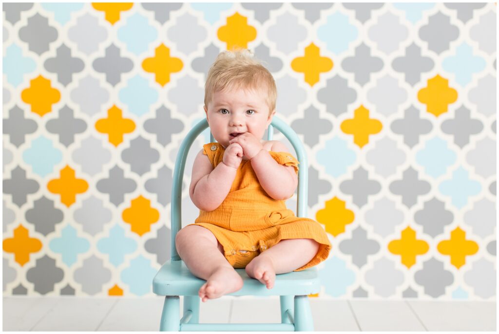 Sitter Session | Baby boy in orange romper and blue chair | Iowa Baby Photographer | CB Studio