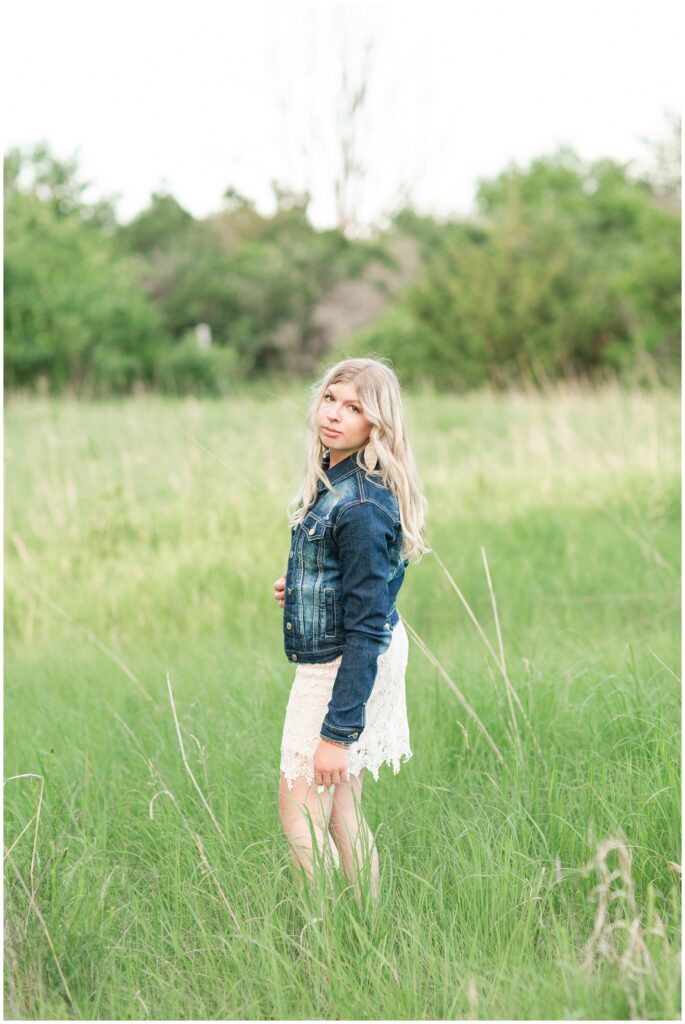 Senior portrait session at a park during golden hour | Senior girl poses in a grassy field | Iowa Senior Photographer | CB Studio