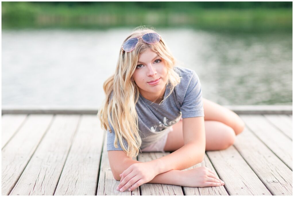 Senior portrait session at a park during golden hour | Senior girl poses on a dock | Iowa Senior Photographer | CB Studio