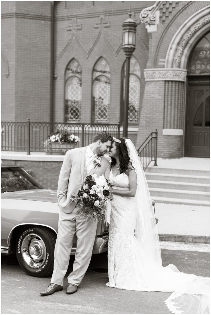 bride and groom pose with Monte Carlo in front of a cathedral | Iowa wedding photographer | CB Studio