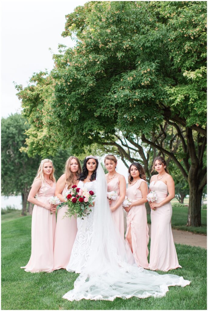 Bride wearing a cathedral length veil and crown and bridesmaids wearing blush pink gowns | Iowa wedding photographer | CB Studio