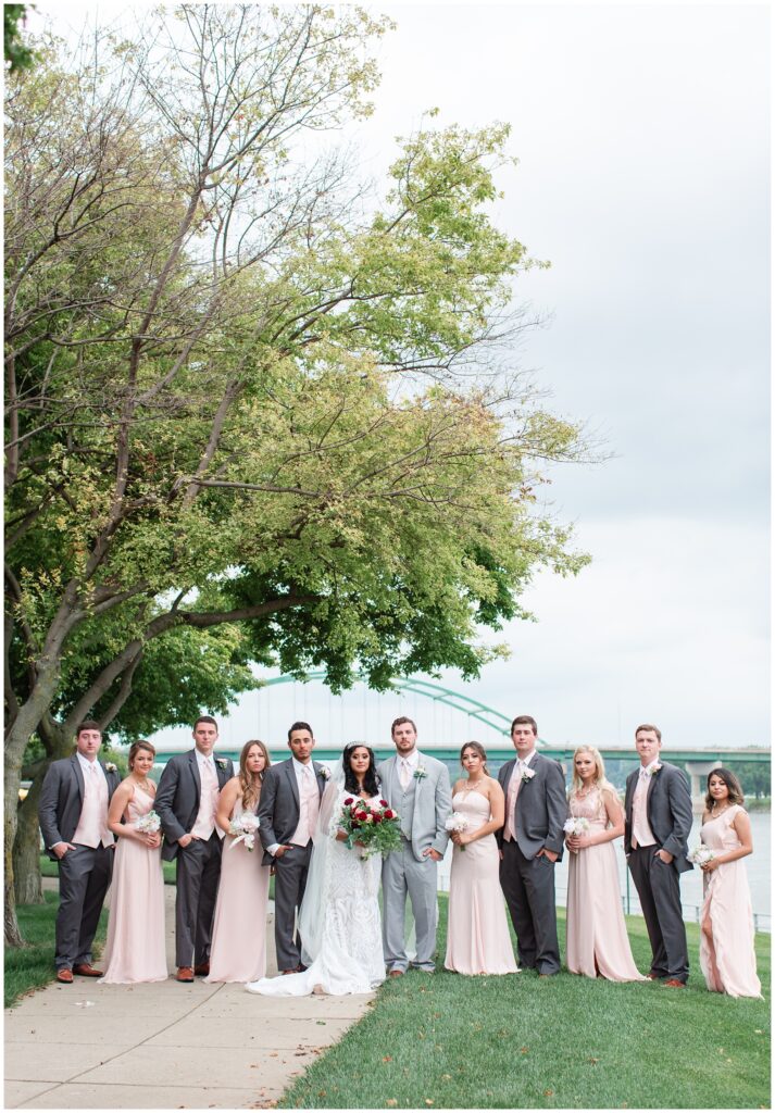 wedding party by the Sioux City bridge wearing blush pink gowns and grey tuxs | Iowa wedding photographer | CB Studio