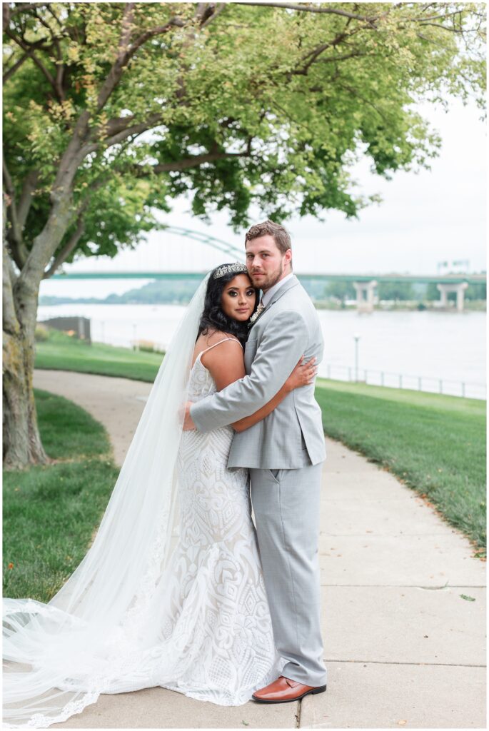 bride and groom pose by the Sioux City bridge and the Delta Marriot Hotel in Sioux City | Iowa wedding photographer | CB Studio