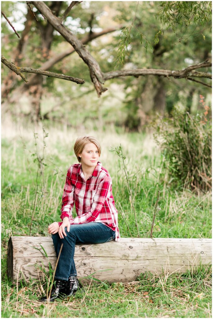Senior poses in a grassy field | Iowa Senior Photographer | CB Studio