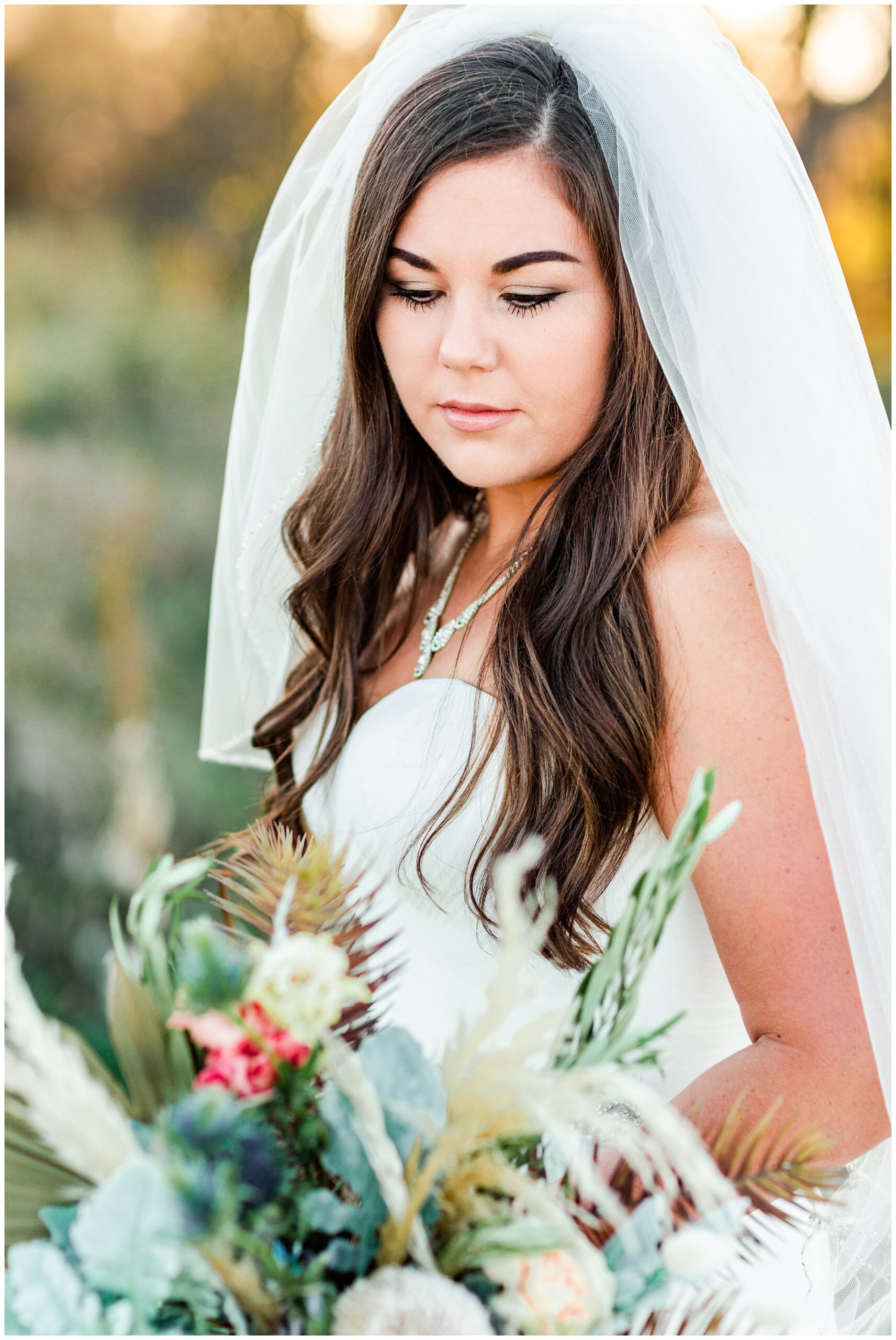 Bridal portrait looking down on a beautiful bouquet of soft florals