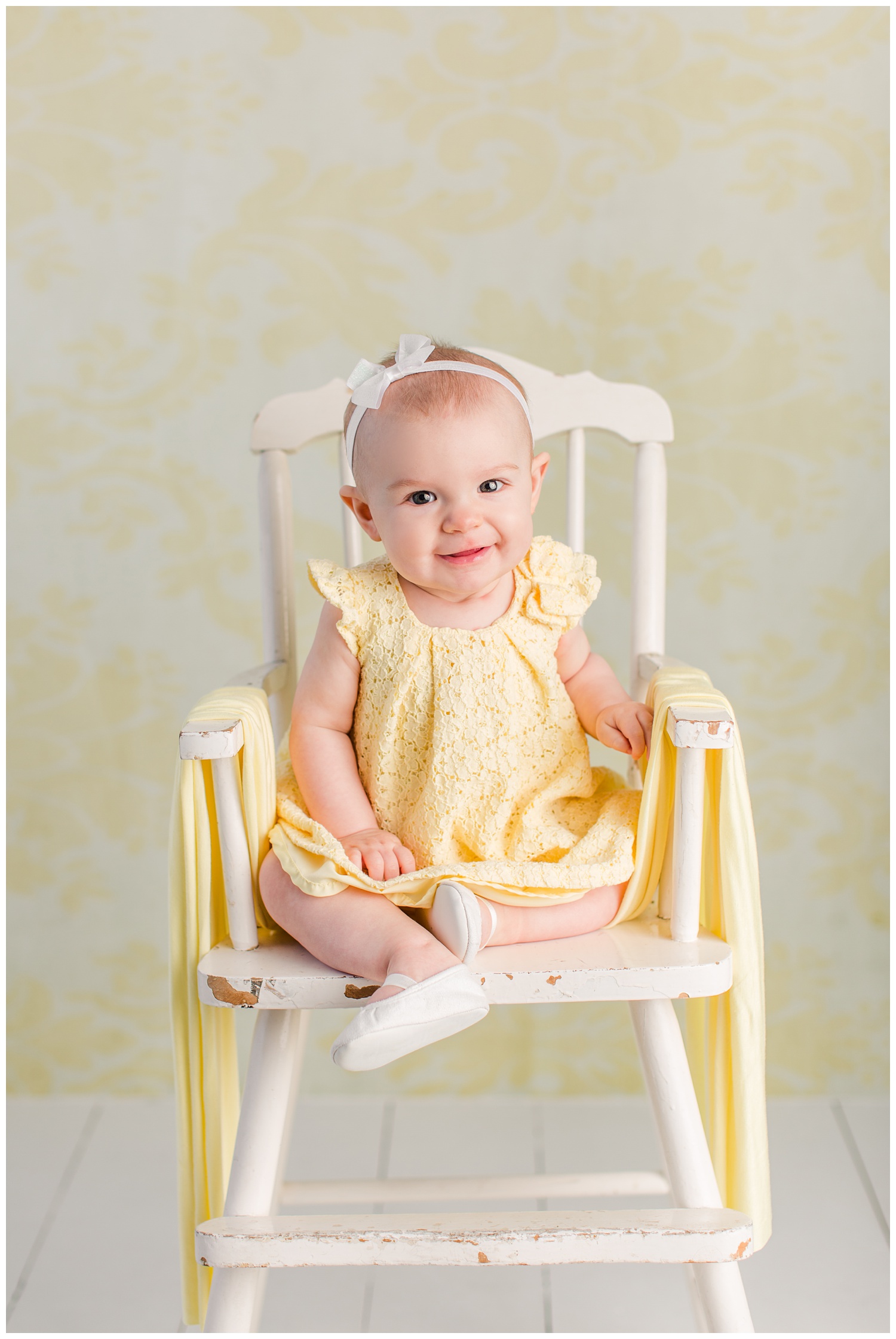 Baby Nora poses in her yellow eyelet Easter dress in an antique high chair.
