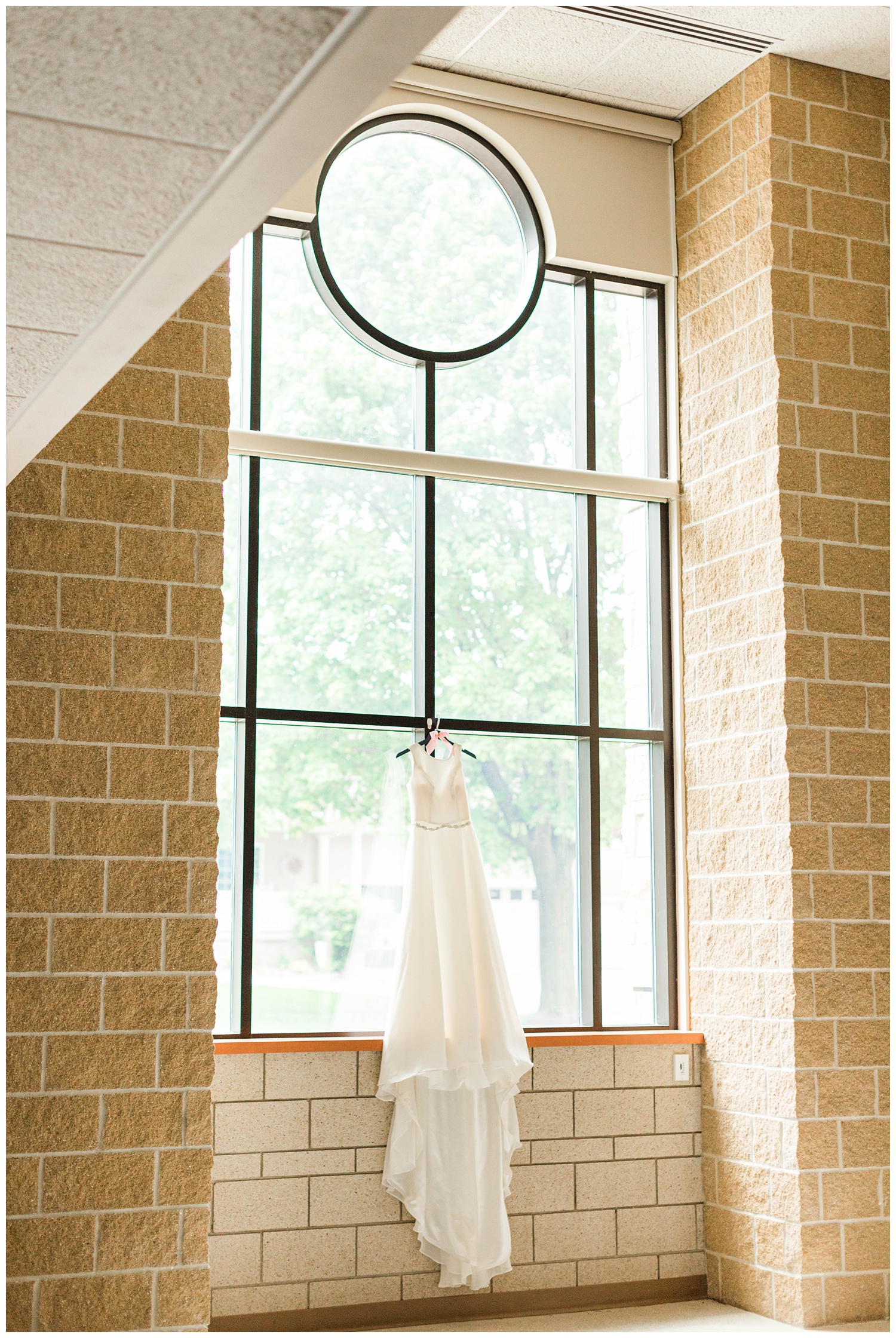 Ever London wedding dress by Justin Alexander hangs in the church window | CB Studio