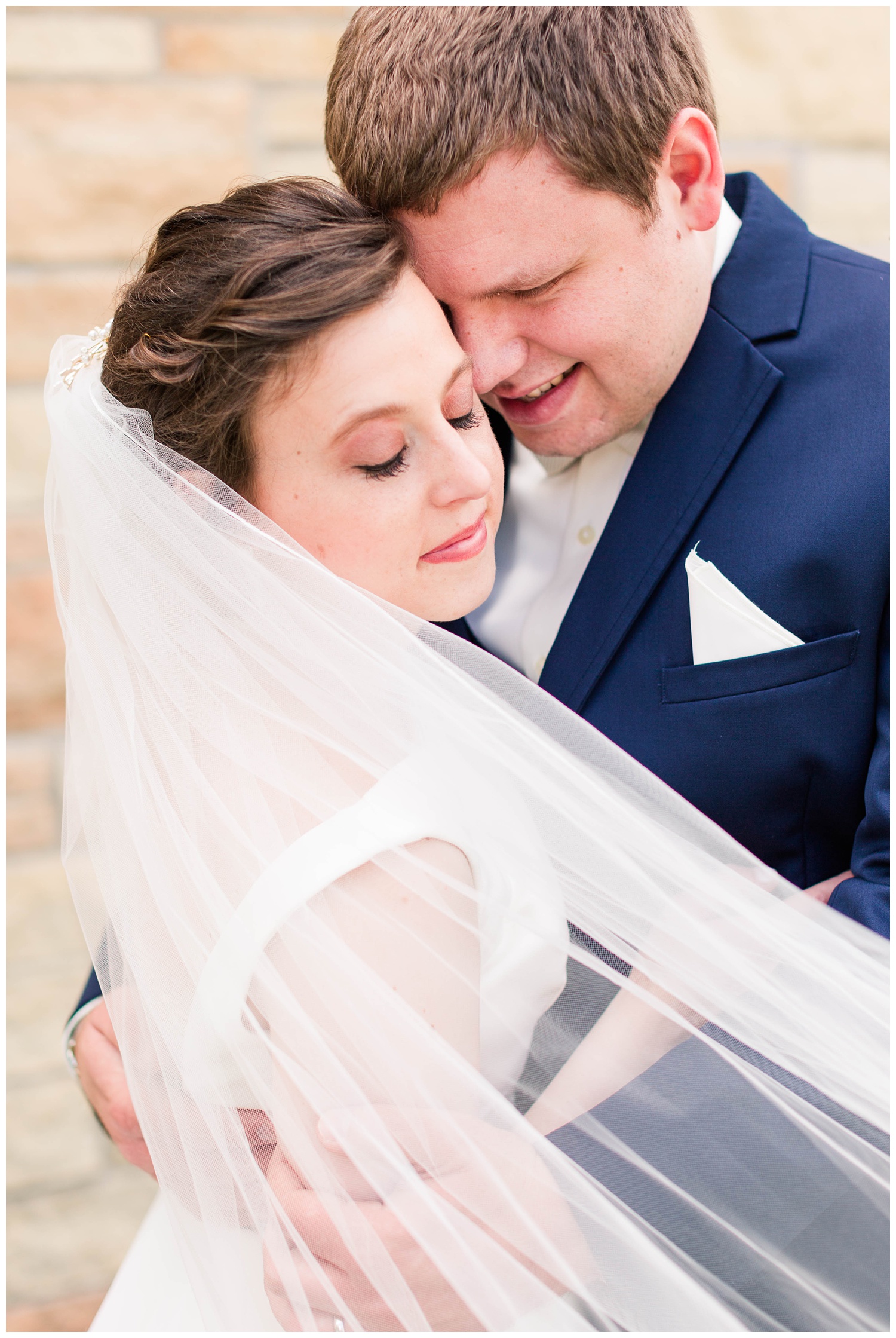 Bride and groom nuzzle in close while the veil swoops in front | CB Studio