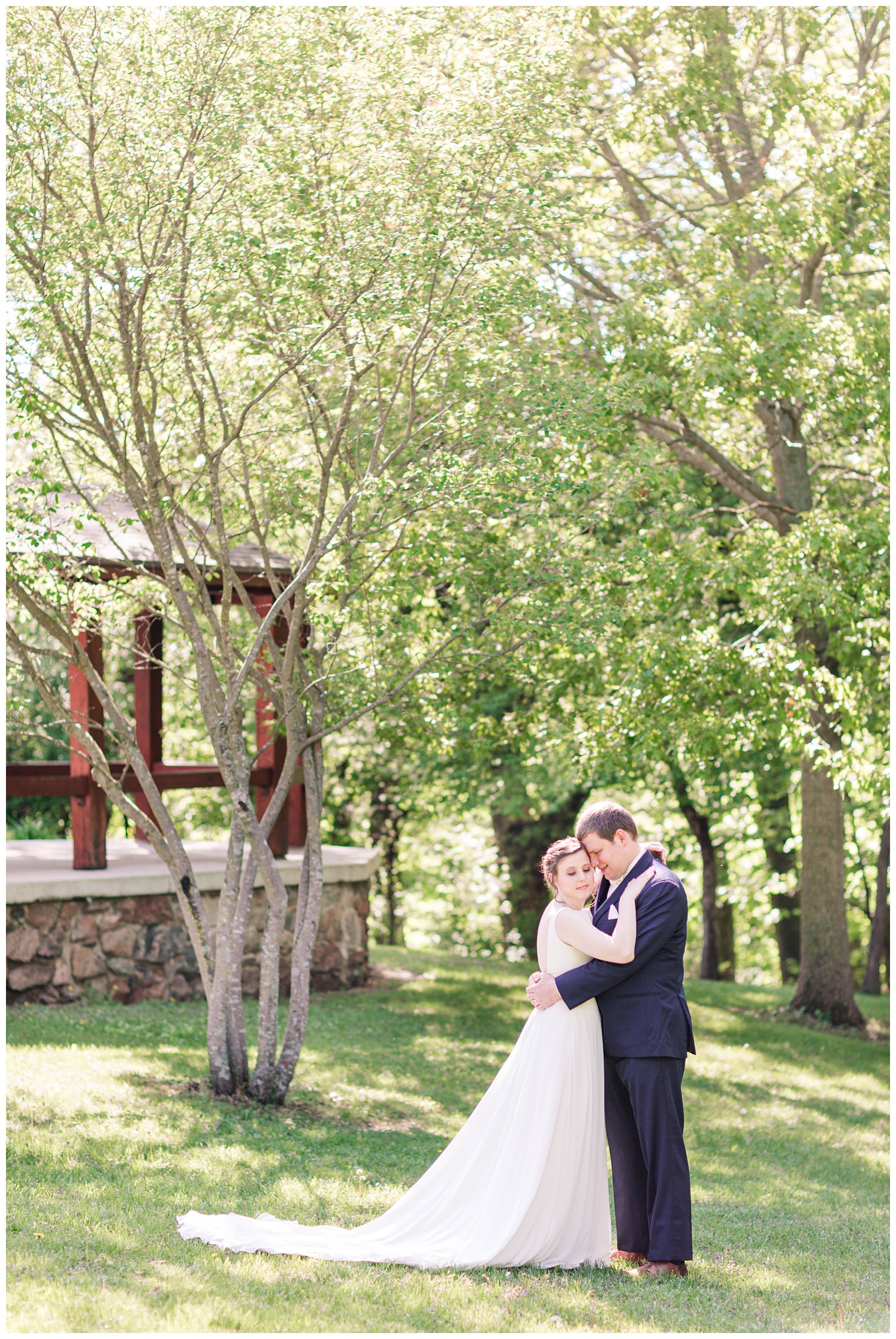 Bride and groom nuzzle in close with a scenic view in Call Park Algona Iowa | CB Studio