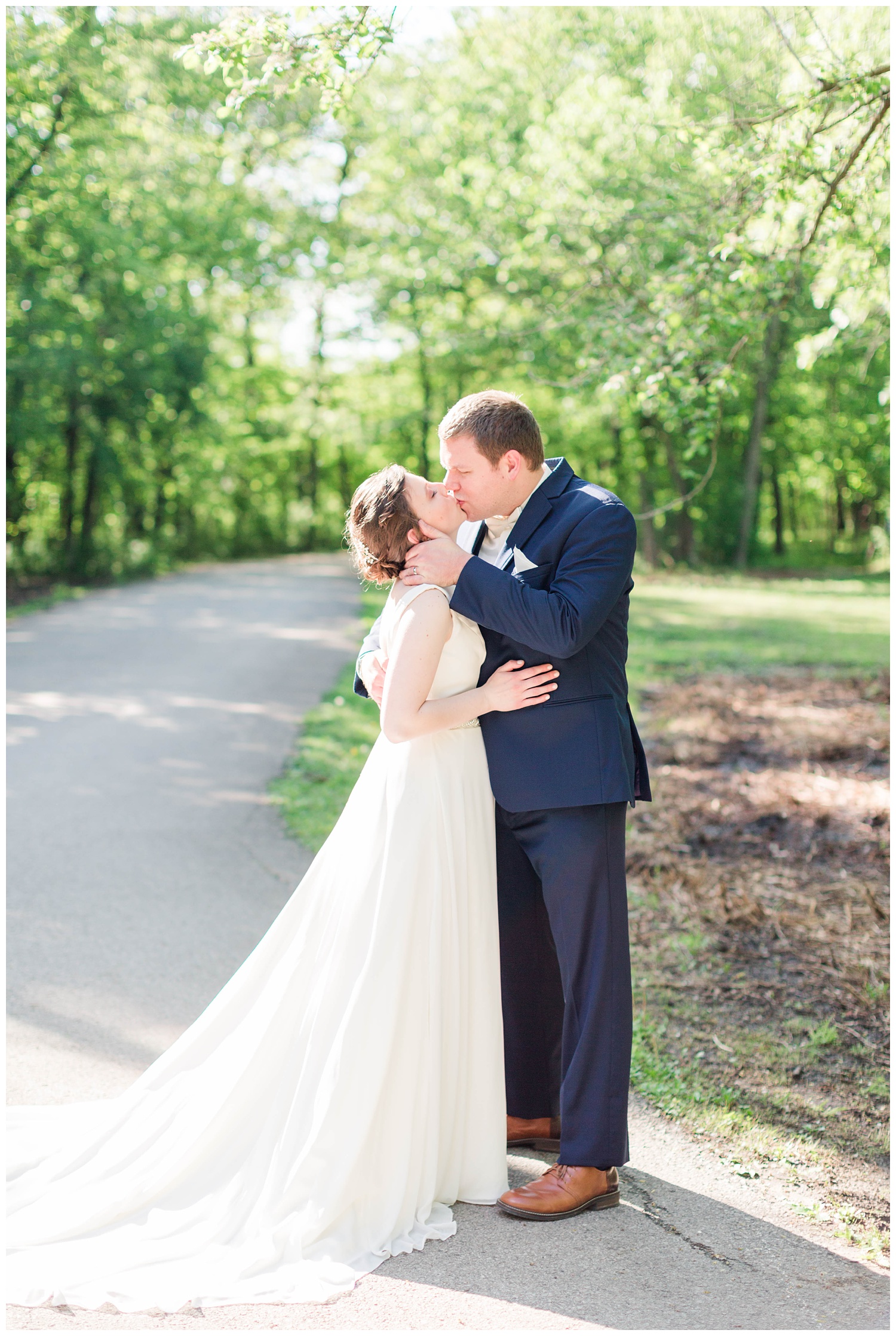 Bride and groom kiss on a scenic path in Call Park Algona Iowa | CB Studio