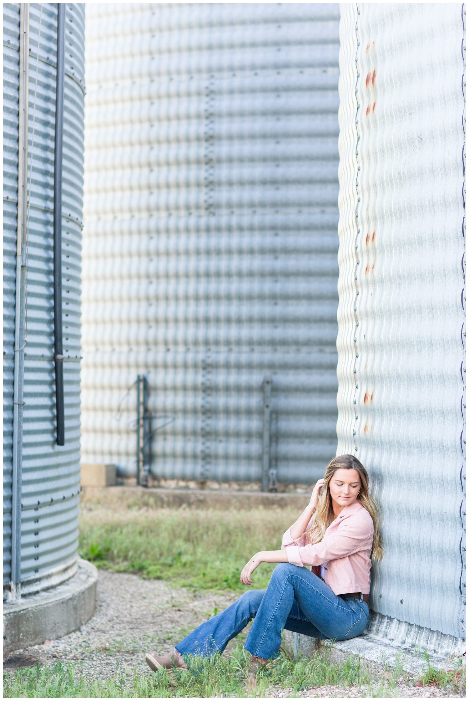 Senior girl sits next to a grain bin in rural north central Iowa | CB Studio