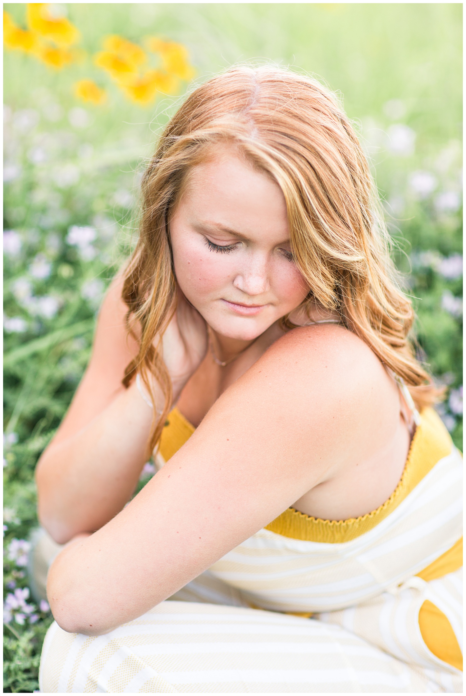 Senior girl wearing a cream and mustard jumpsuit sitting in a flower field at Smith Lake, Algona, Iowa | CB Studio