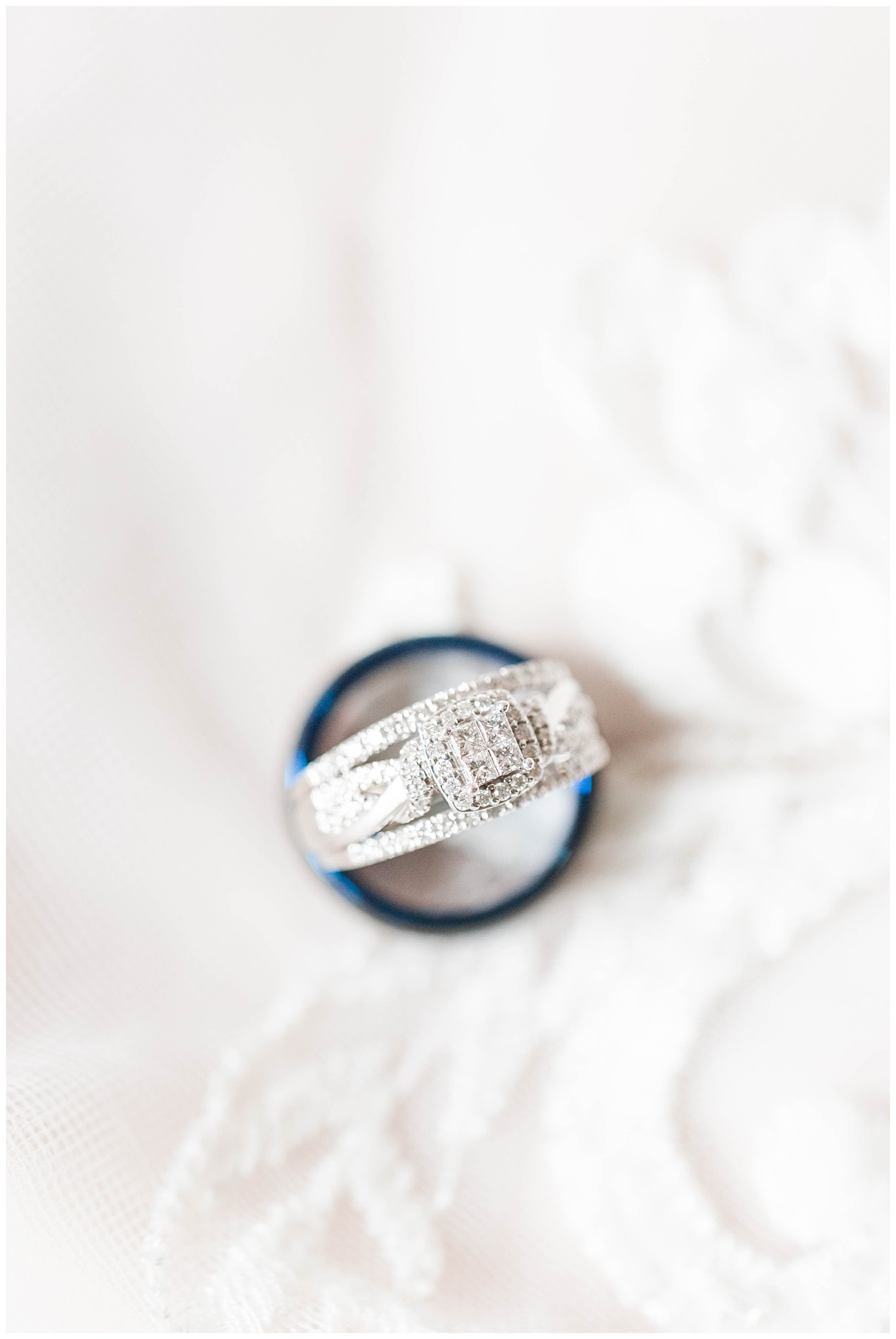 Bridal wedding band and groom's ring delicately placed on the lace of a wedding dress. | CB Studio