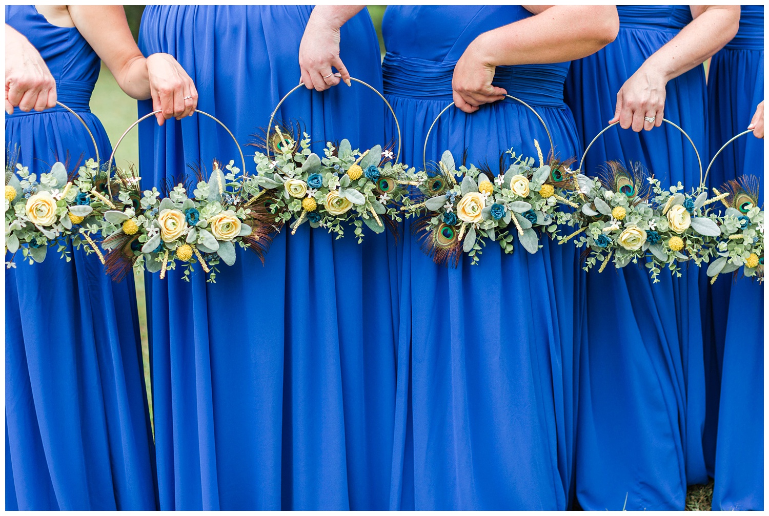 Royal blue and yellow hoop bouquets featuring peacock feathers. | CB Studio