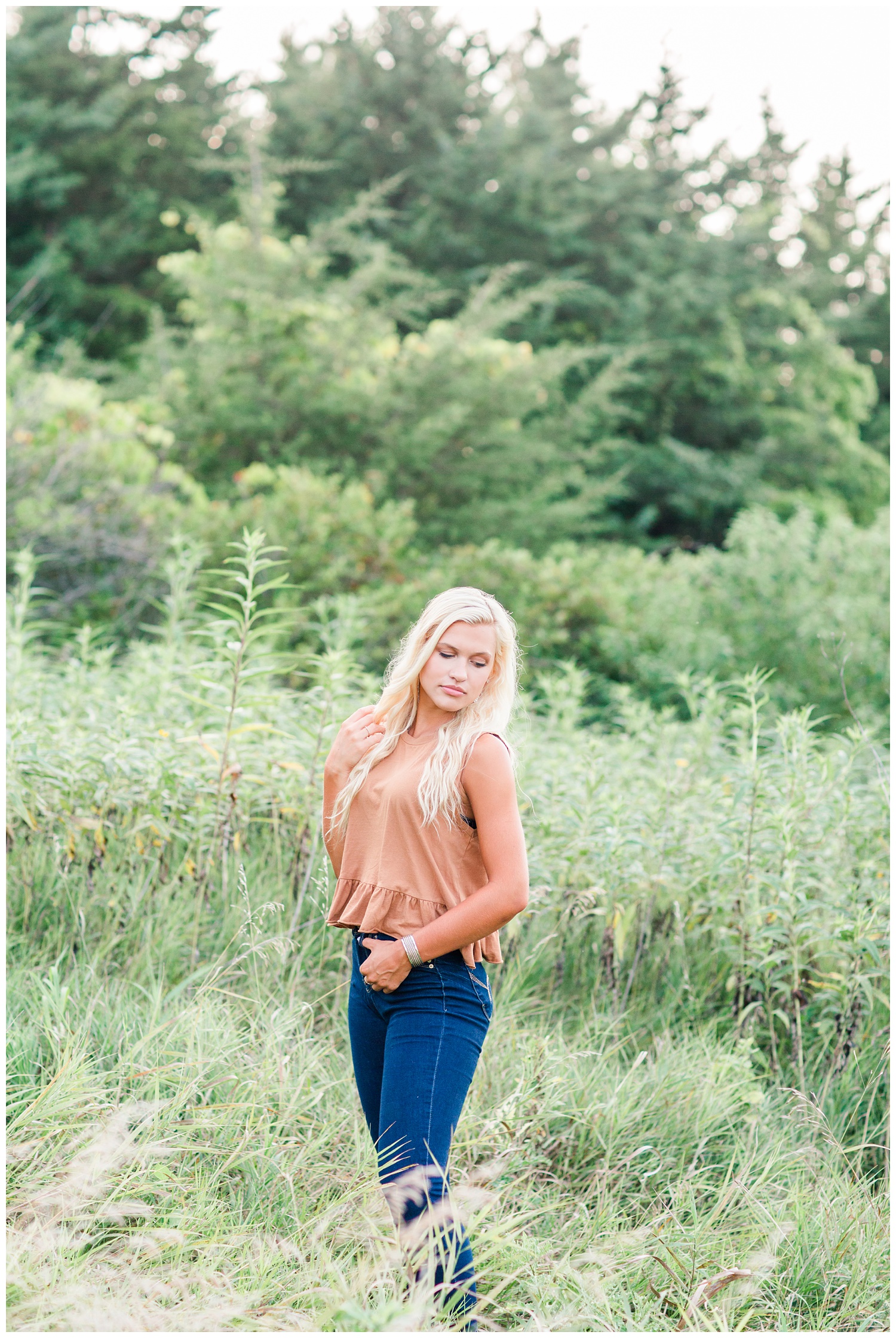 Senior girl standing in a grassy field at Water's Edge Nature Center in Algona, Iowa | CB Studio