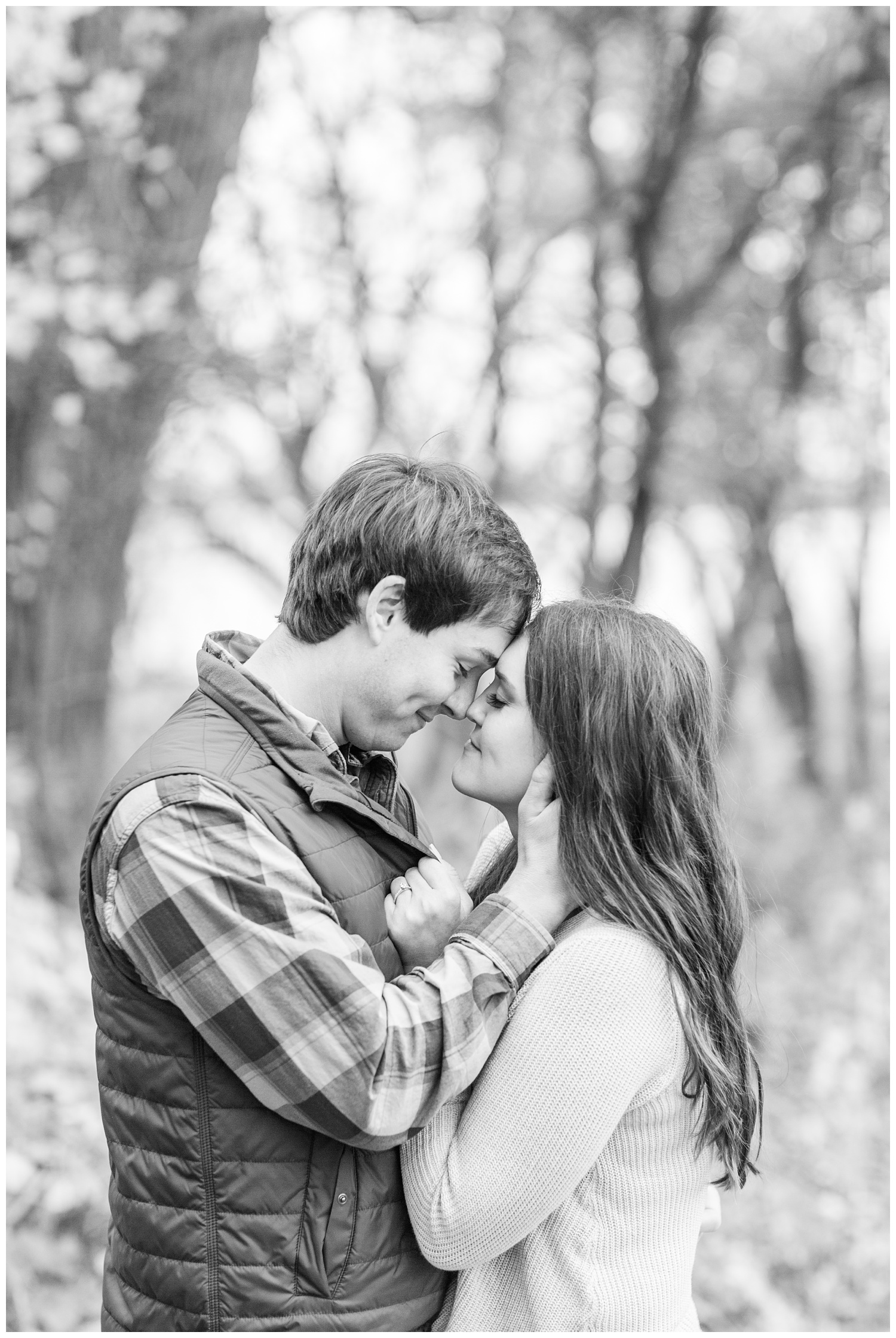 Fall in Iowa, Brady slowly pulls Jenna in for a kiss in the middle of an autumn path at Lost Island Nature Center | CB Studio