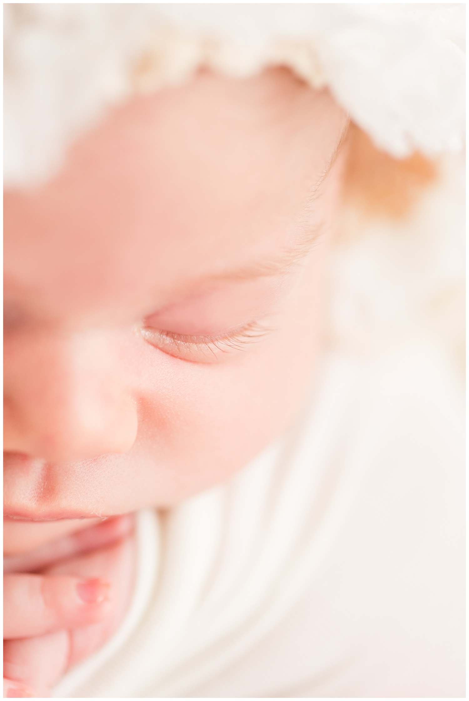 Newborn wearing all white closeup of baby girl's eyelashes | CB Studio