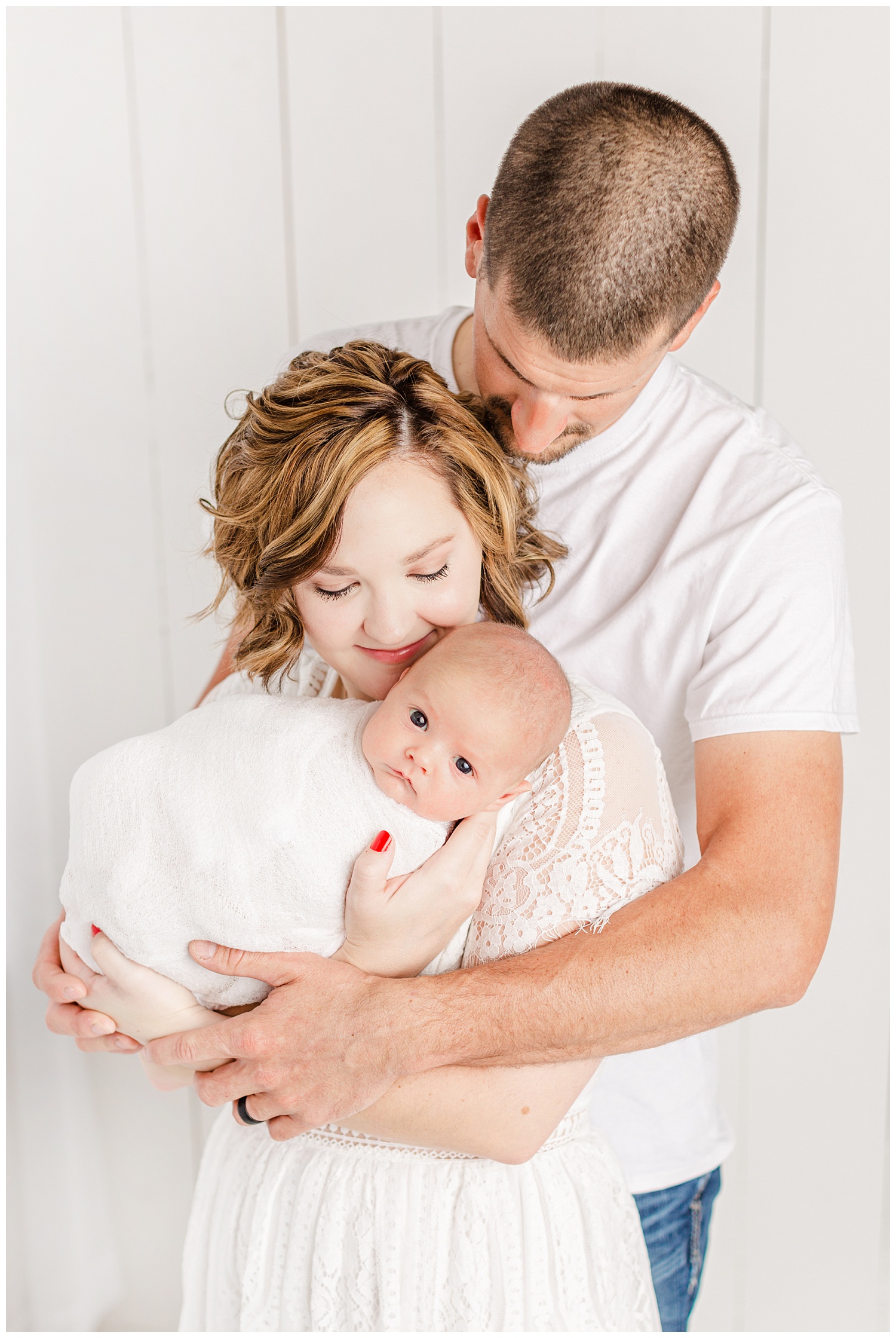 Bree and Josh dressed in white snuggle their new baby boy | CB Studio