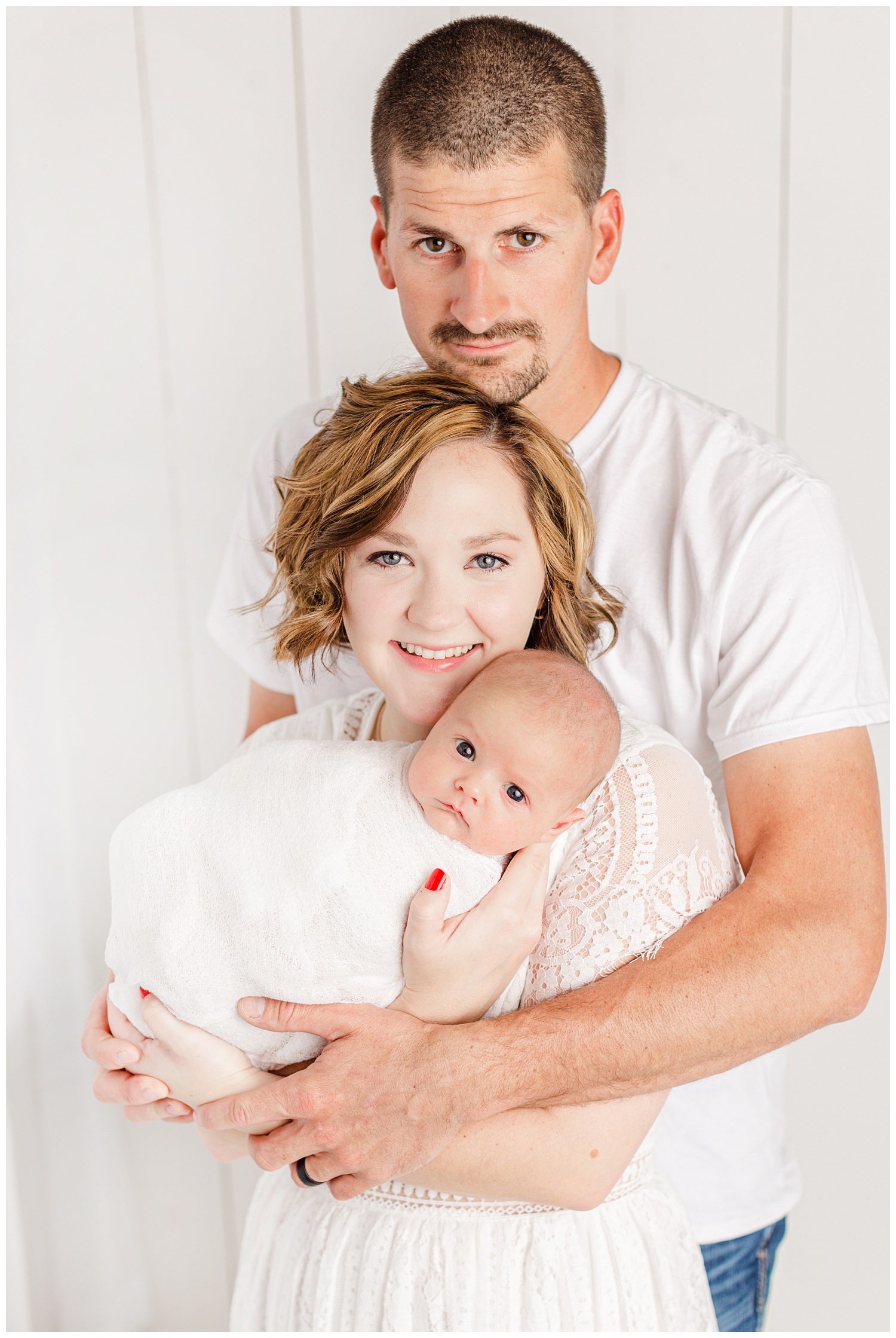 Bree and Josh dressed in white snuggle their new baby boy | CB Studio