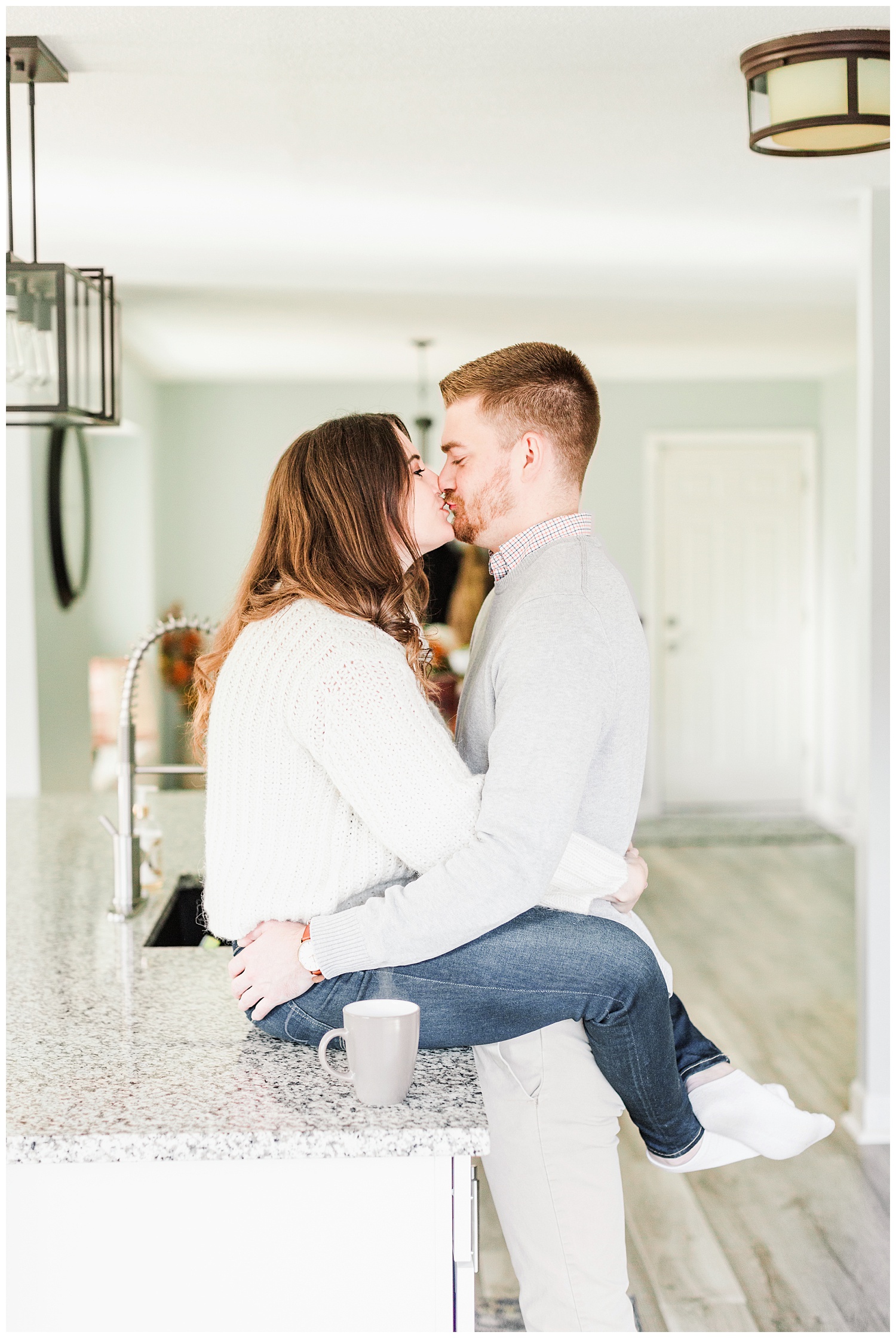 Dustin kisses Jenna while she sits on their kitchen counter | Cozy Kitchen Engagement Session | CB Studio