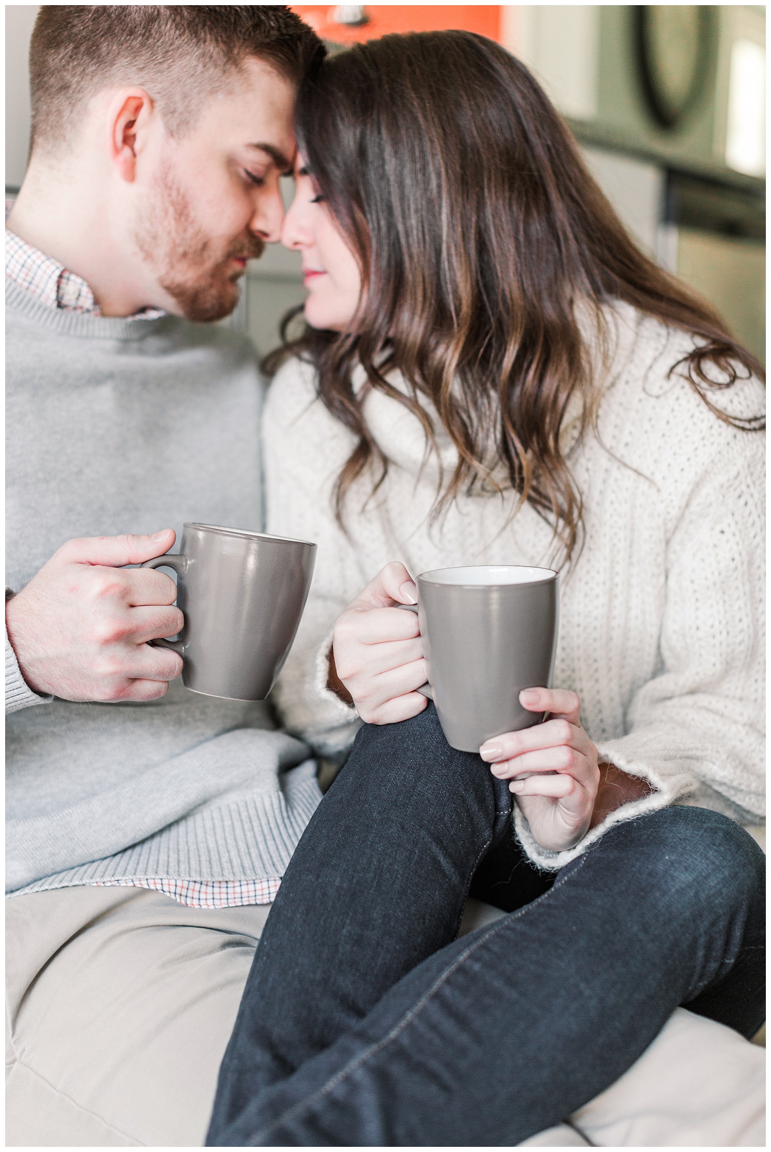 Dustin and Jenna nuzzle together on their kitchen floor with a cup of coffee | Cozy Kitchen Engagement Session | CB Studio