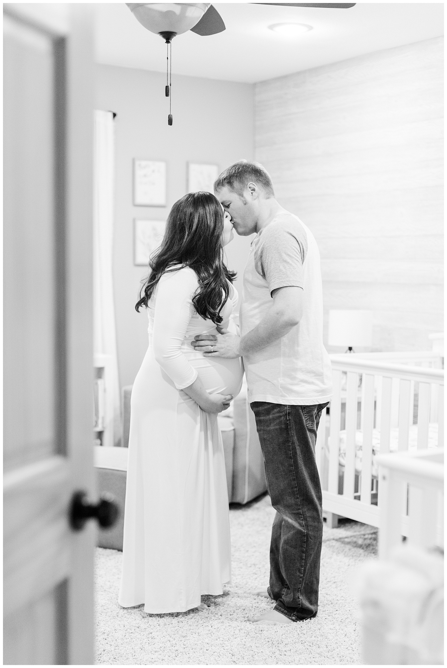 Expecting mom and dad embrace in their newly designed nursery as they await the arrival of their boy/girl twins | CB Studio