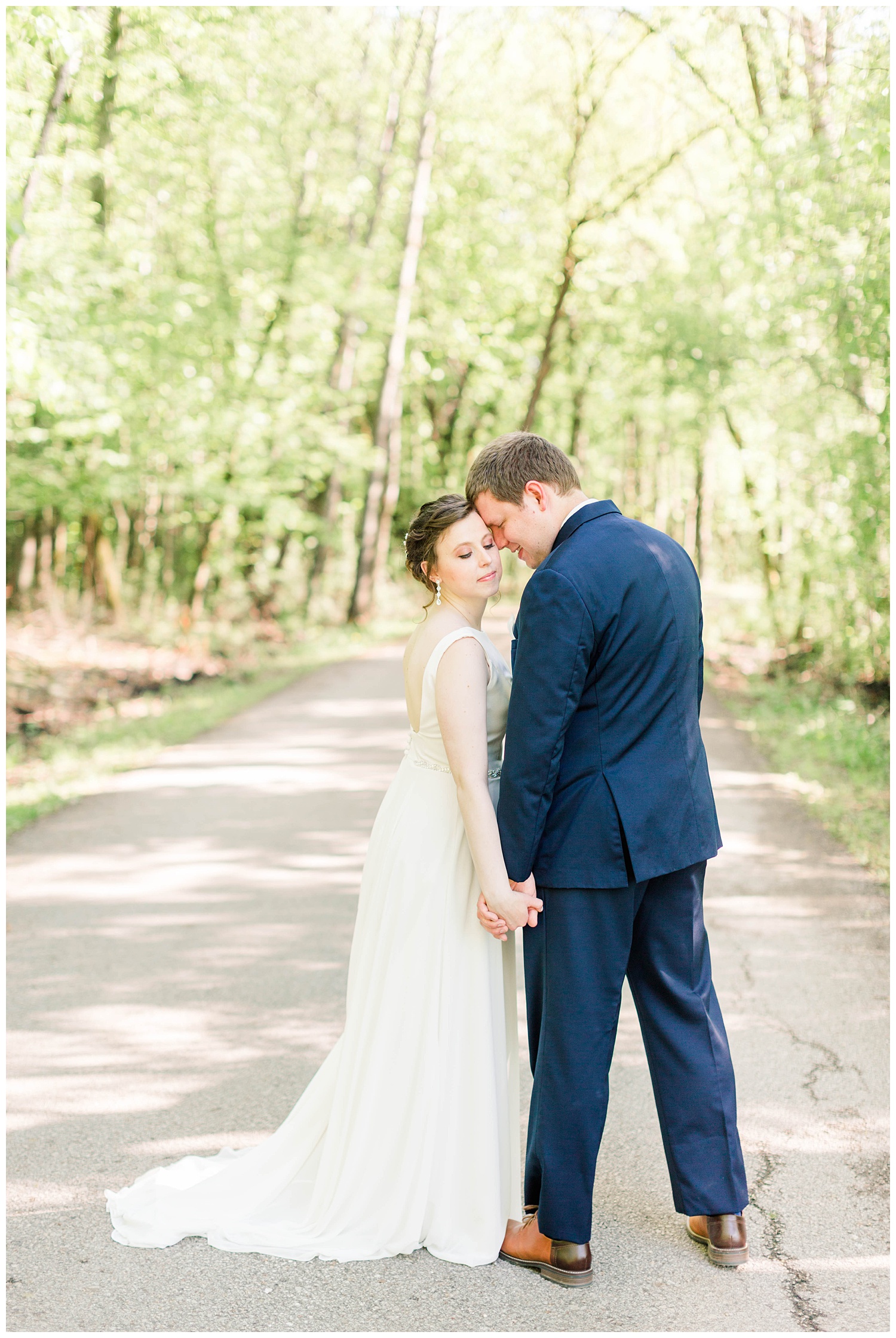 Ryan gently nuzzles his new bride in the middle of a forest pathway | Iowa Wedding Photographer