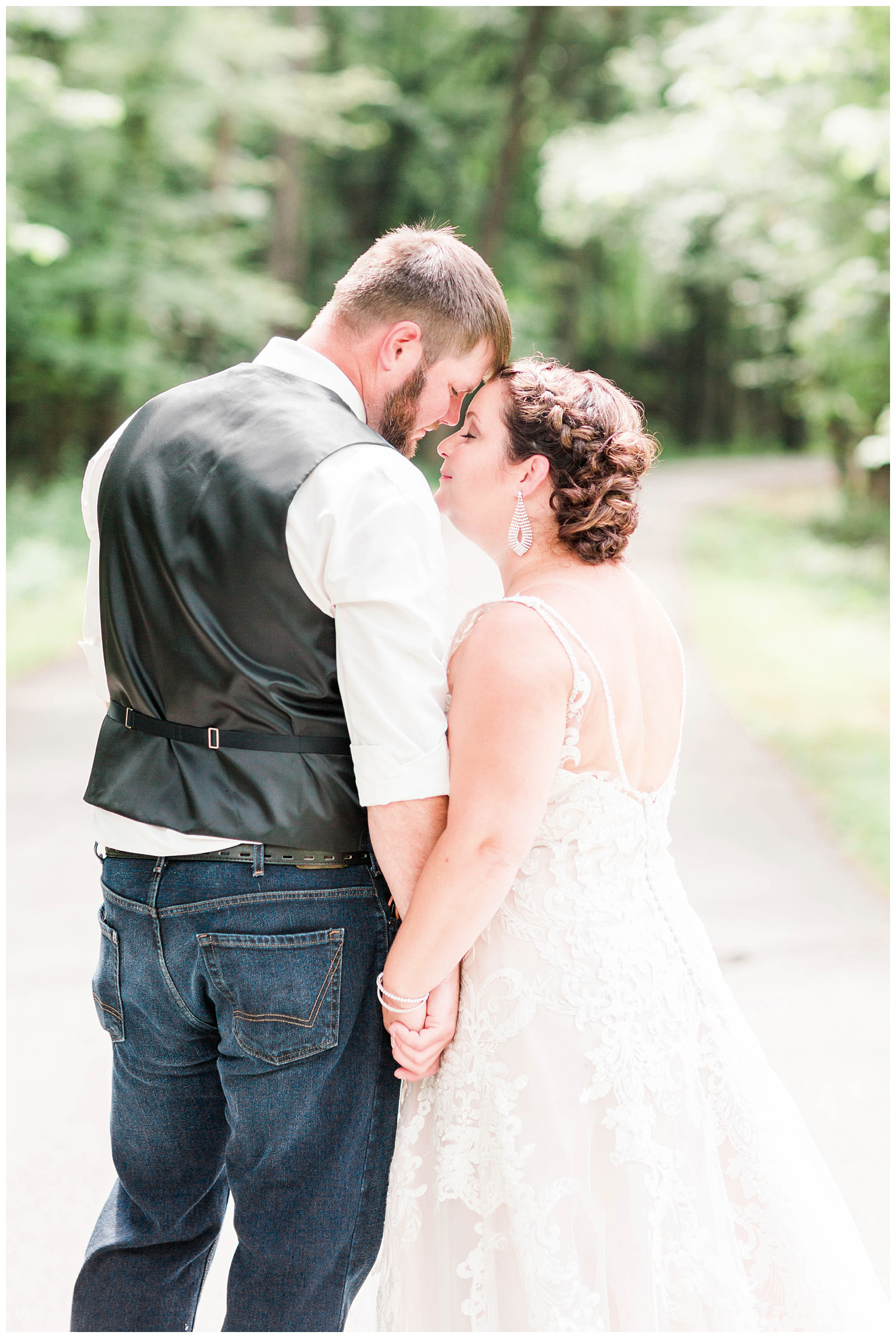 Travis gently nuzzles his new bride in the middle of a forest pathway | Iowa Wedding Photographer