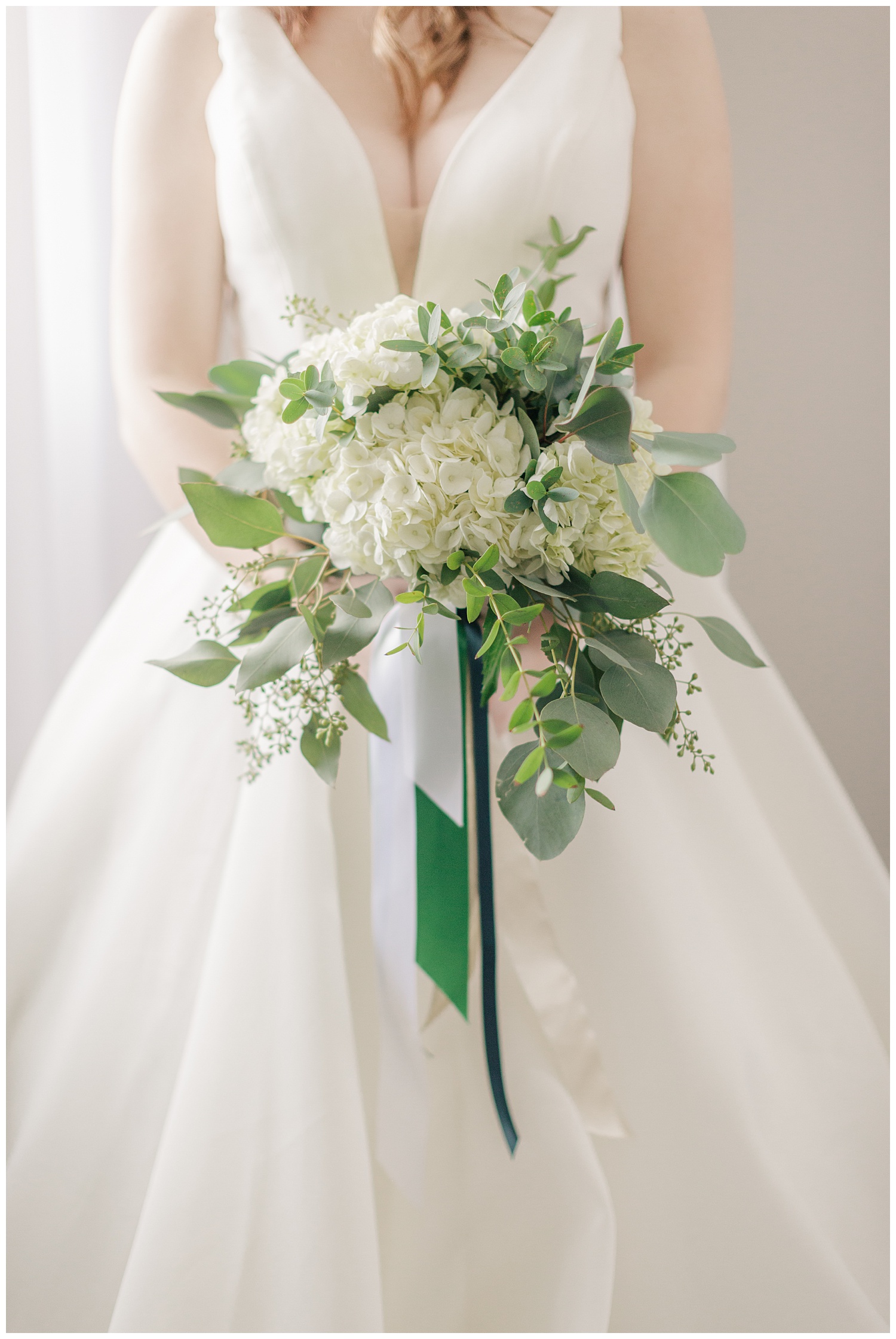 White hydrangea and eucalyptus variety bridal bouquet tied in white and emerald ribbon | CB Studio 