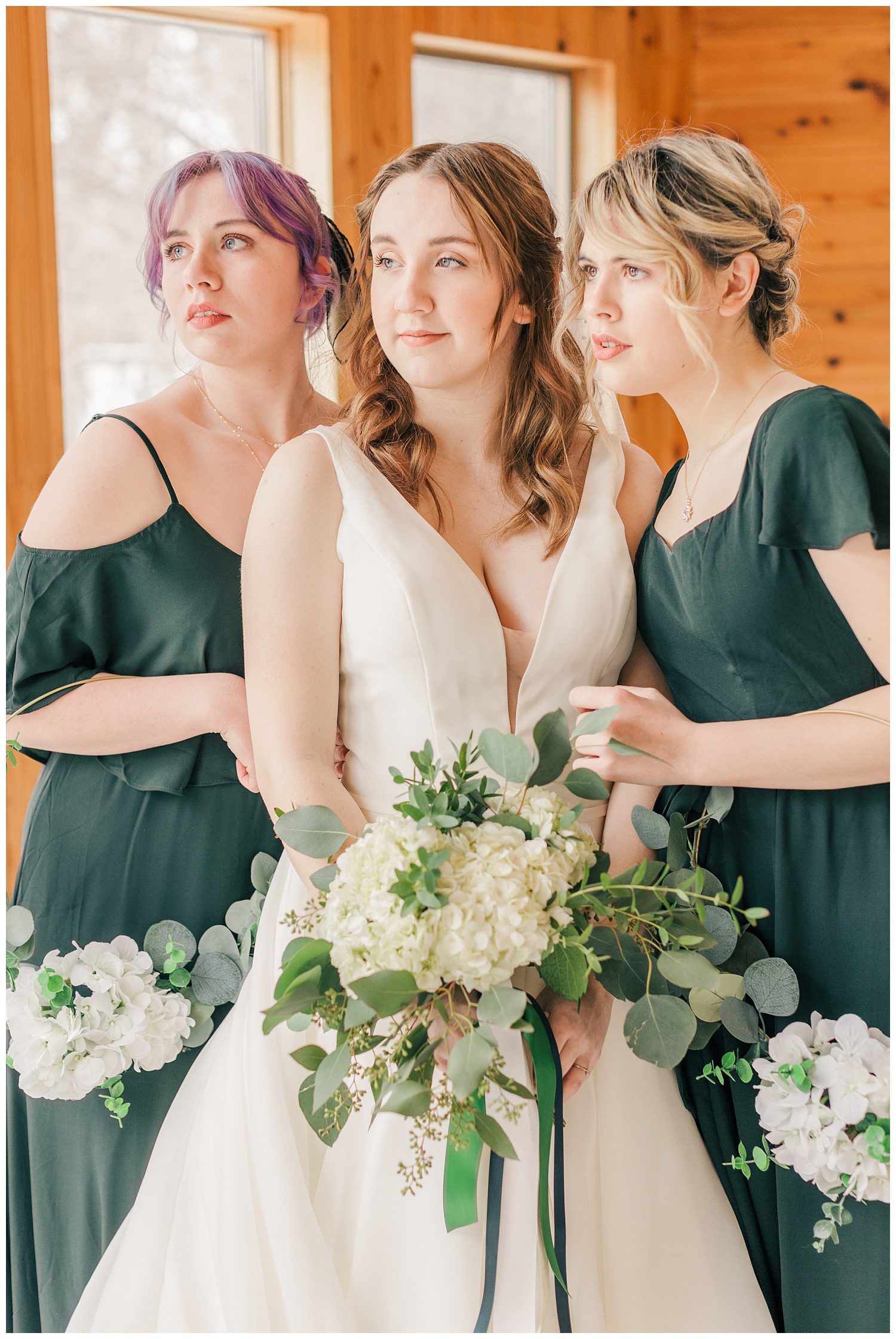 Raven and her bridesmaids dressed in emerald green, holding white hydrangea and eucalyptus hoop bouquets | CB Studio