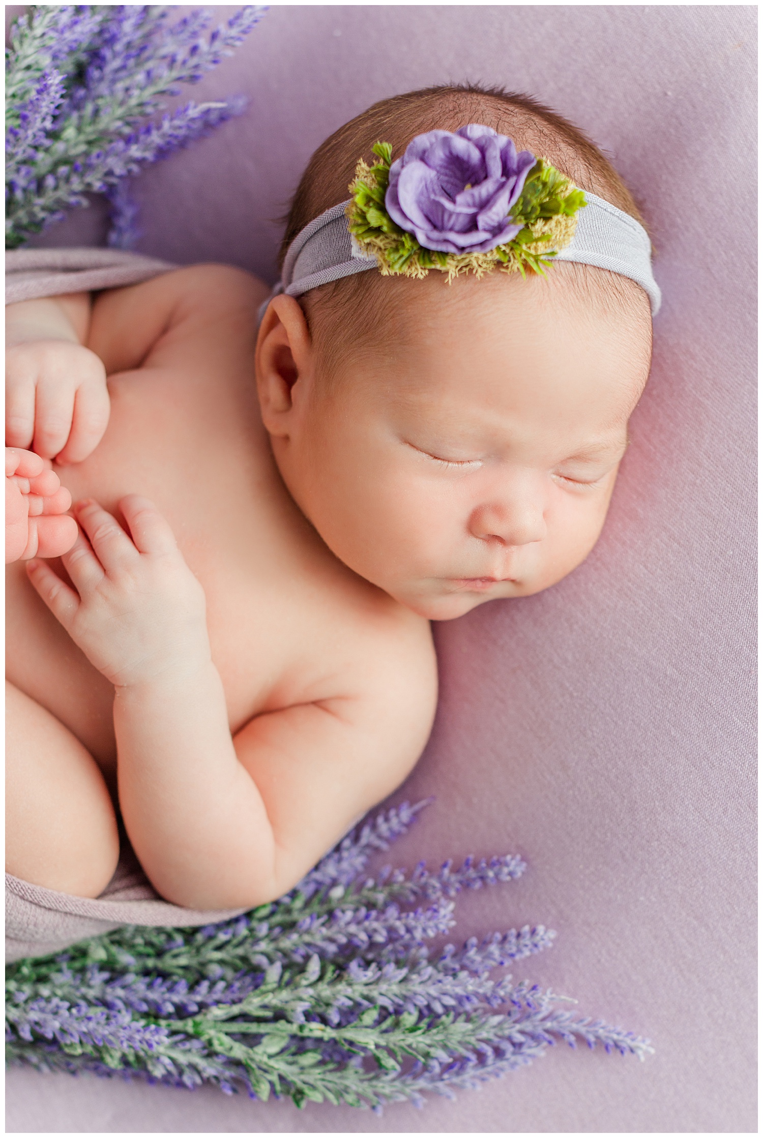 Baby Emma snuggled up with purple tones and spring florals | CB Studio