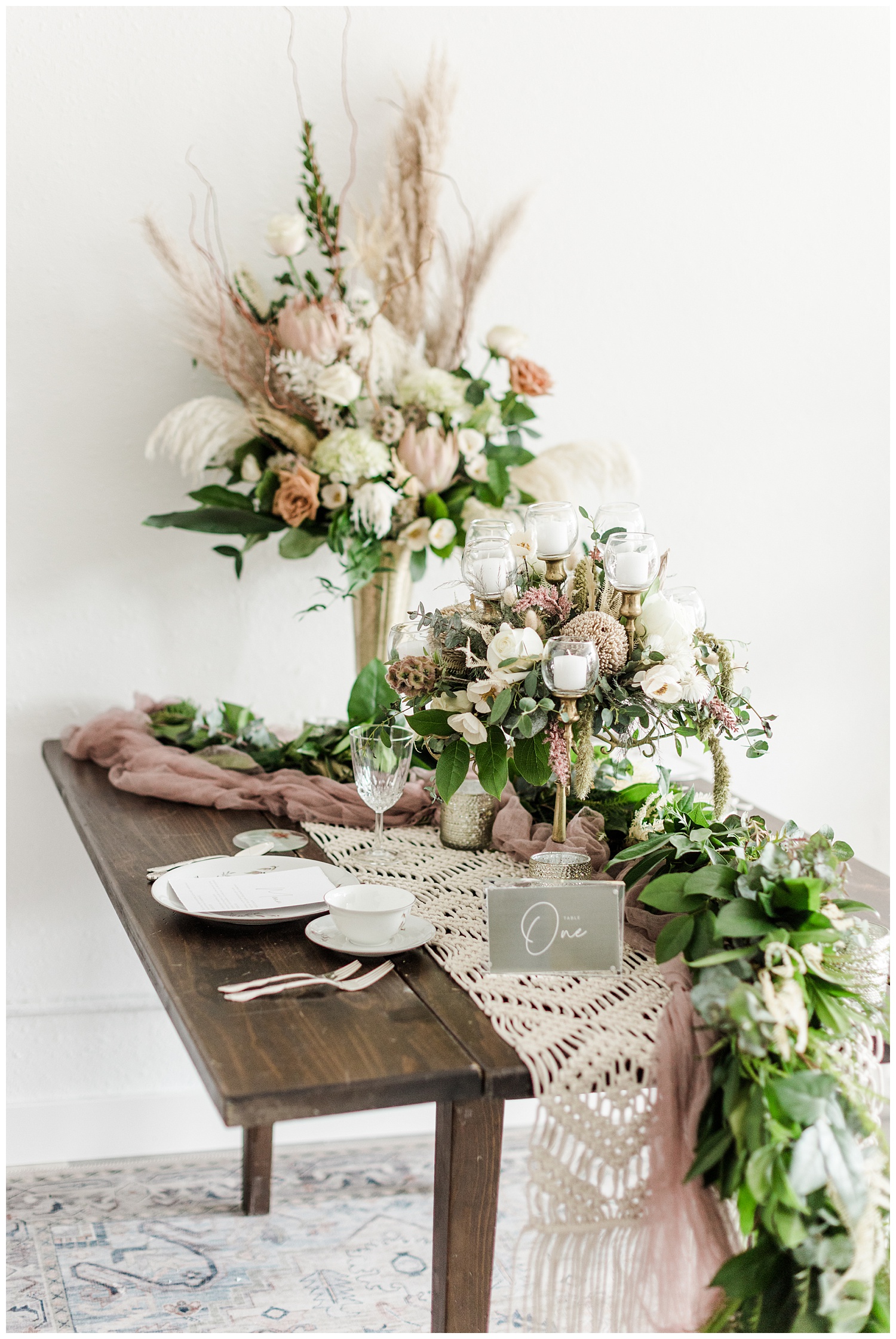 Vintage blush wedding tablescape complete with a gold candelabra, dried florals with pampas grass, macrame and eucalyptus table runner and antique china | CB Studio