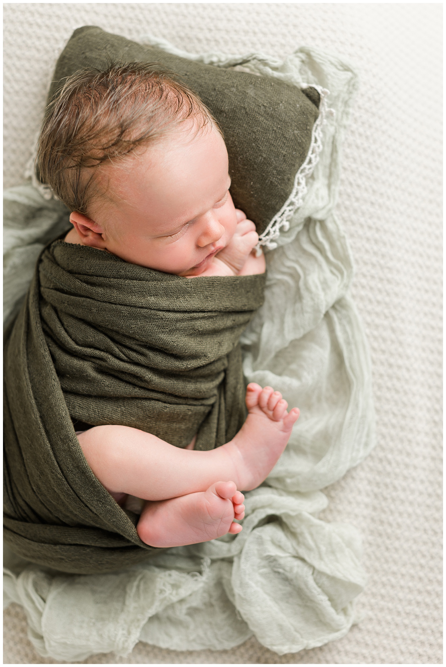 Baby Connor swaddled up in olive green | CB Studio