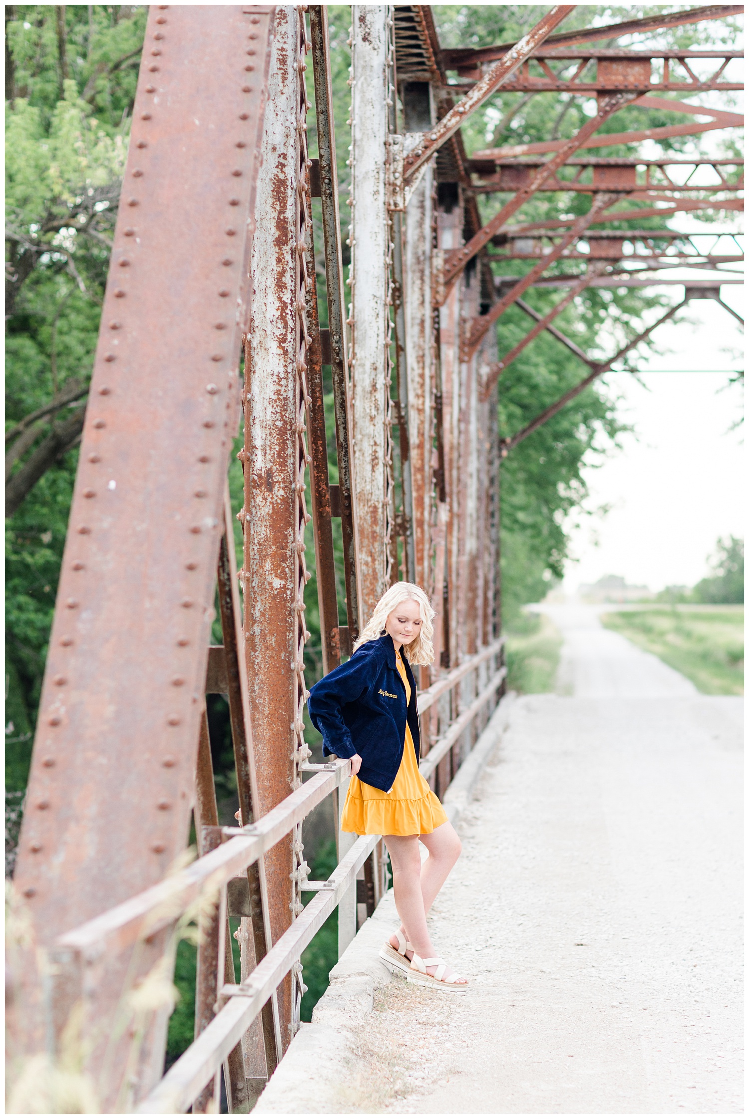 Senior girl Molly wearing her FFA jacket leaning against an old trussle bridge | CB Studio