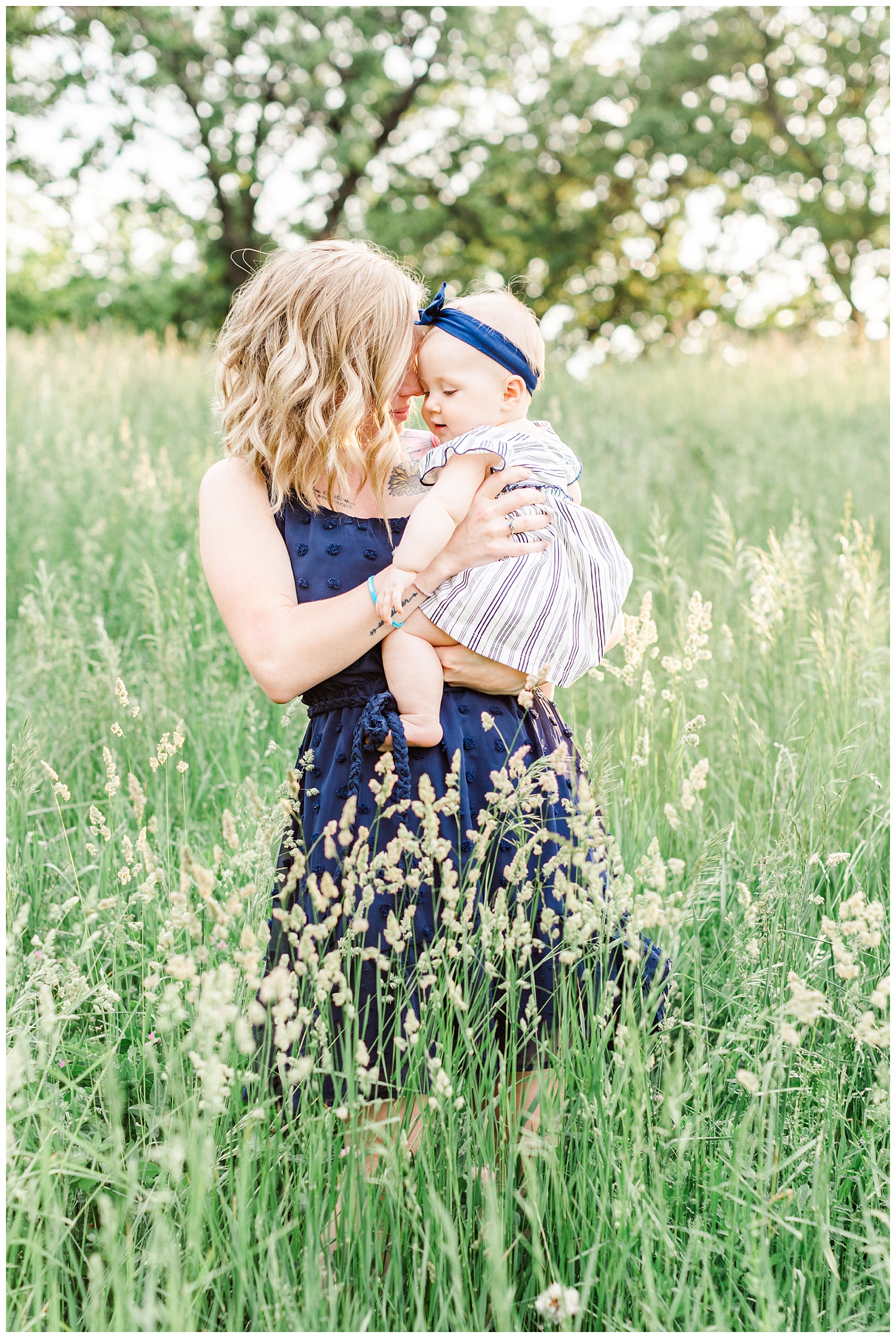 Mama embraces her baby girl at holden hour in a grassy field in Iowa | CB Studio