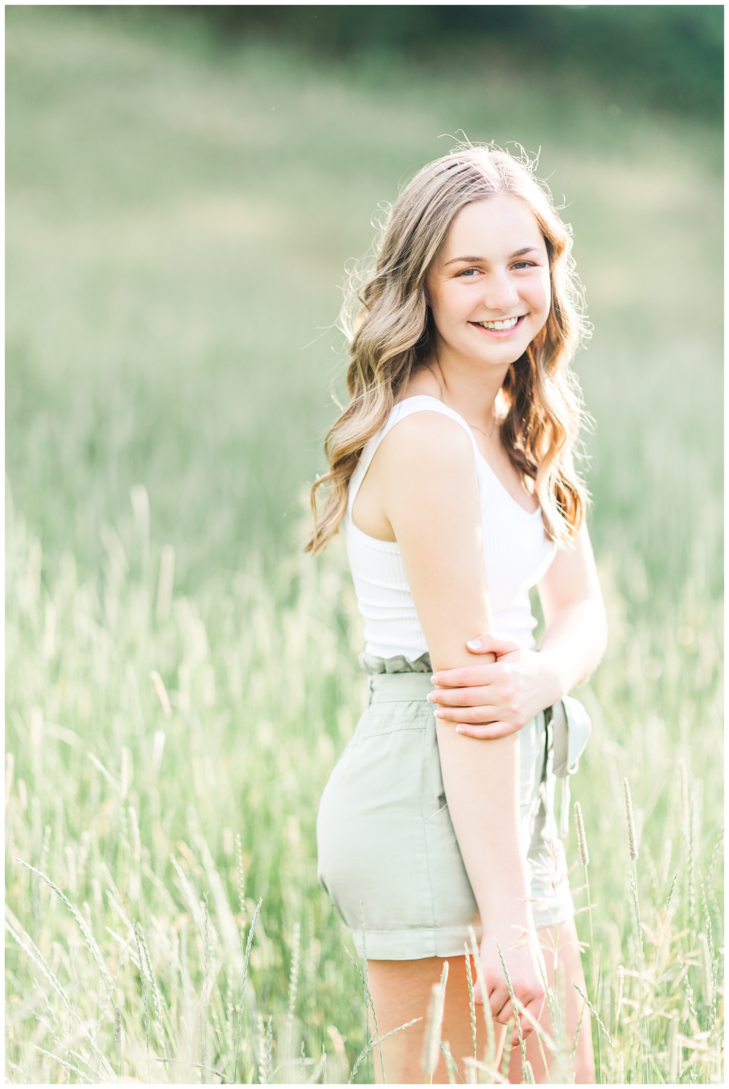 Senior Taylor laughing in a grassy field in Iowa | CB Studio