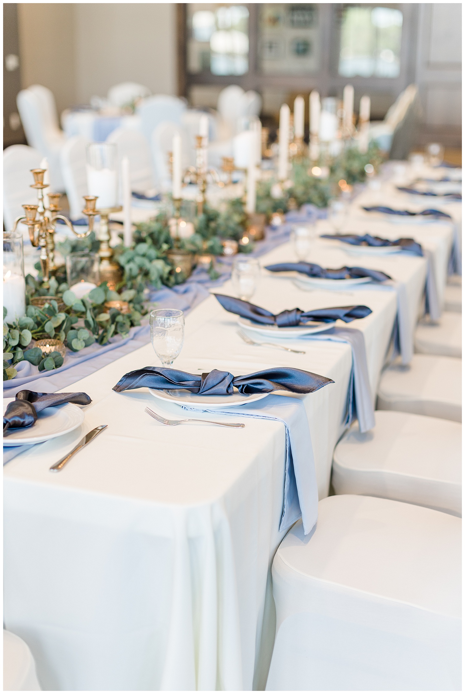 Dusty blue and peach kings wedding table topped with gold vintage candlesticks, eucalyptus and knotted napkins at the Shores at Five Island | CB Studio
