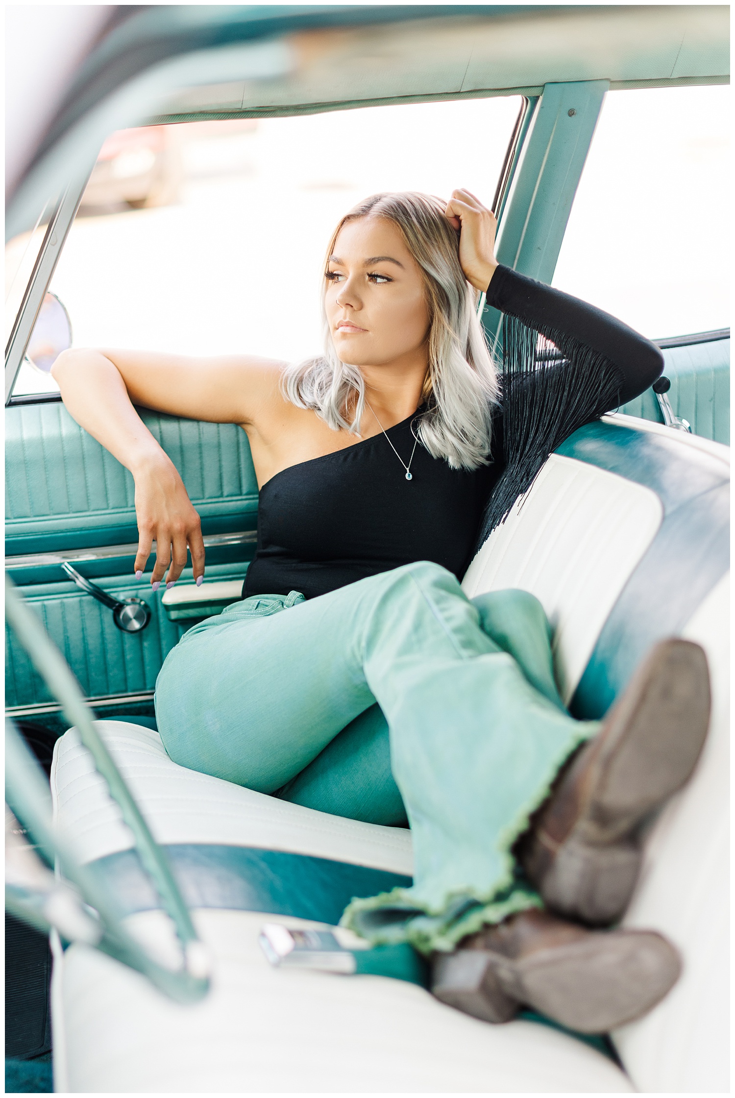 Addison lounges in the front seat of a teal 1967 Chevy Bel Air | CB Studio