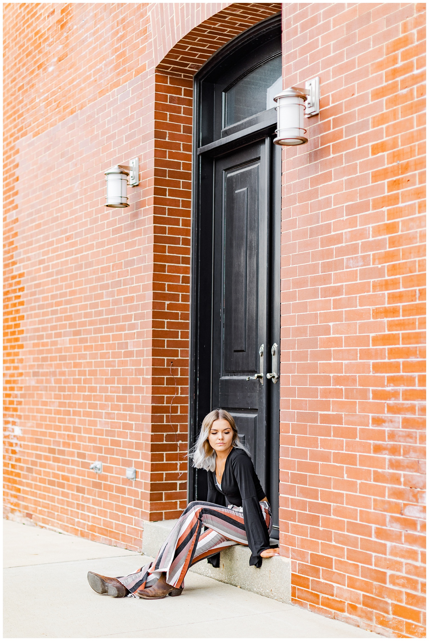 Addison dressed in boho style sits on a door step in downtown Algona, IA | CB Studio