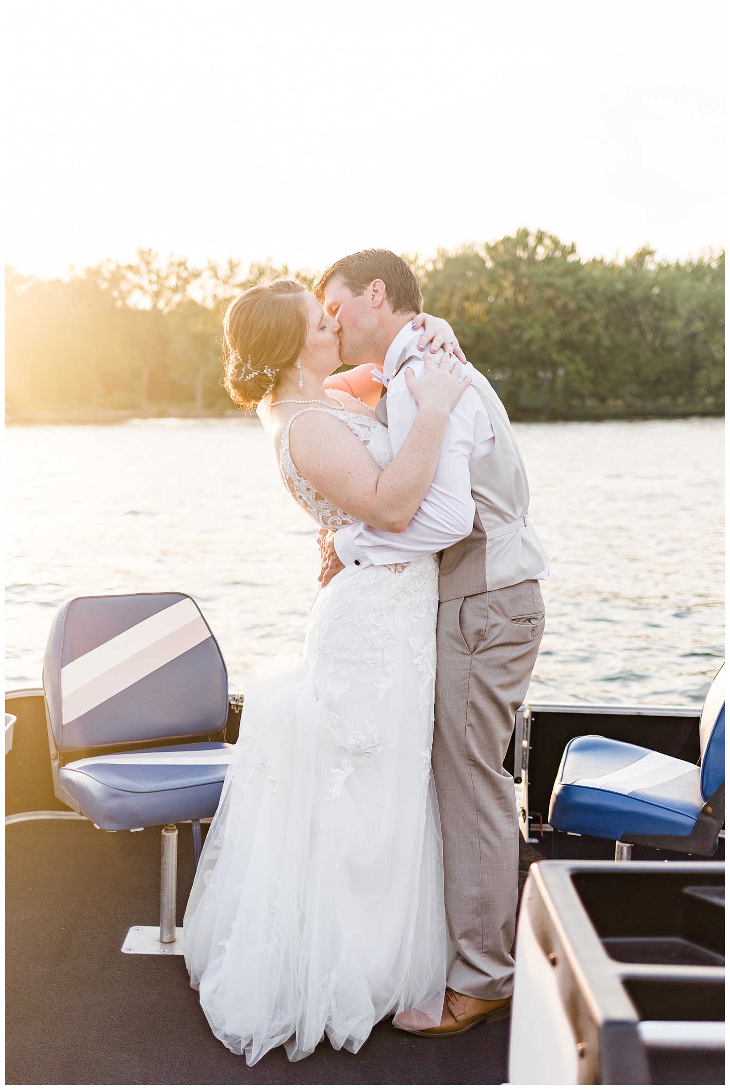 Chris and Hannah share a kiss during sunset on a pontoon on East Okoboji Lake on their wedding day | CB Studio