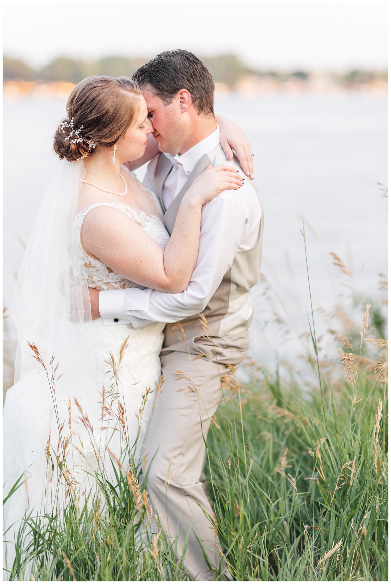 Chris and Hannah embrace in front of East Okoboji Lake on their wedding day | CB Studio