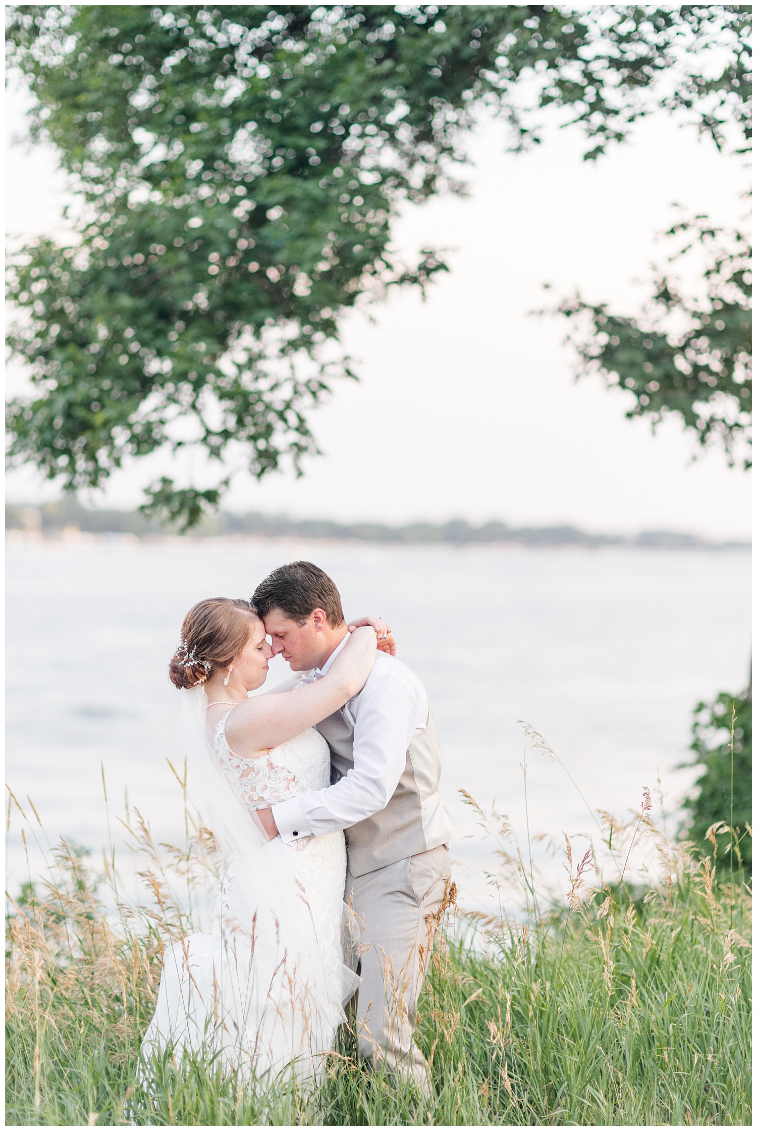 Chris and Hannah embrace in front of East Okoboji Lake on their wedding day | CB Studio