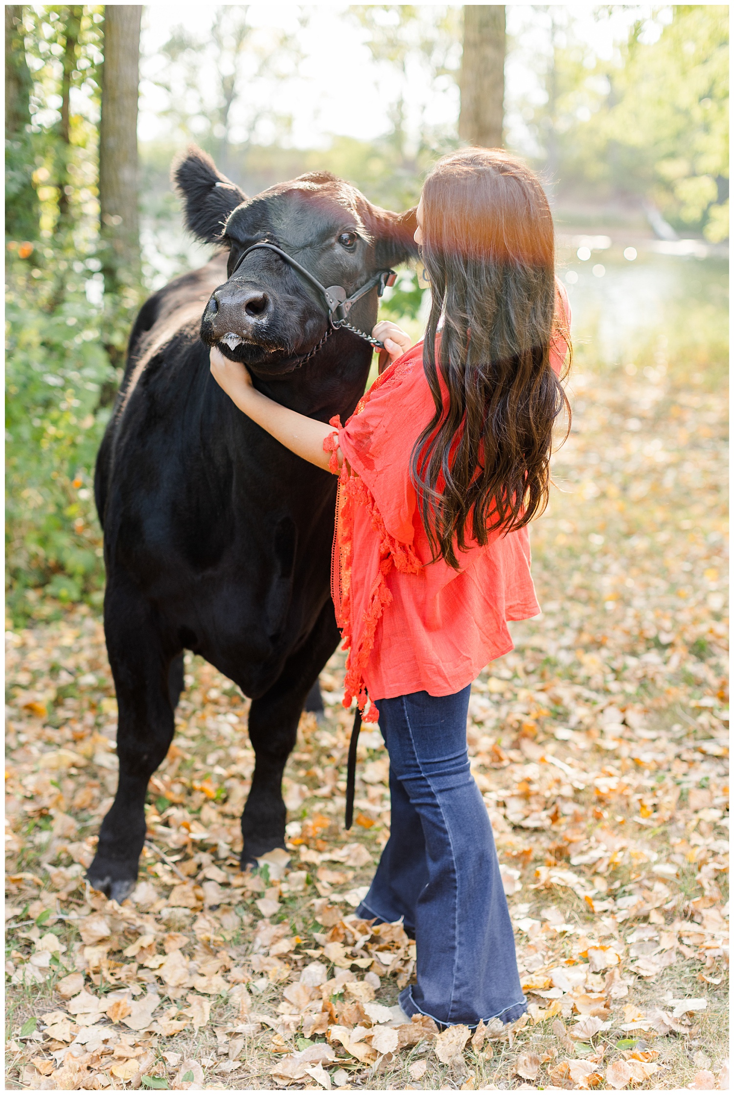 Laney, wearing a coral Kimono, pets her show cow, Queen | CB Studio