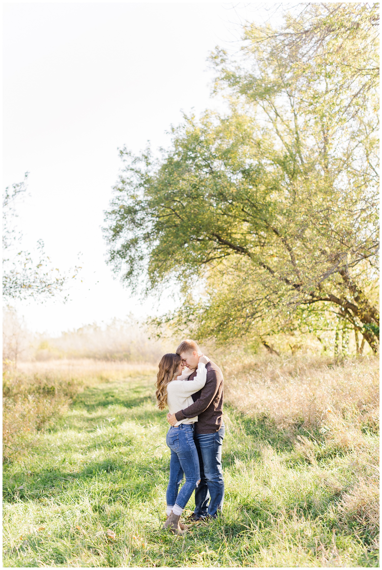 Thad and Ashlyn embrace in a grassy pasture | CB Studio