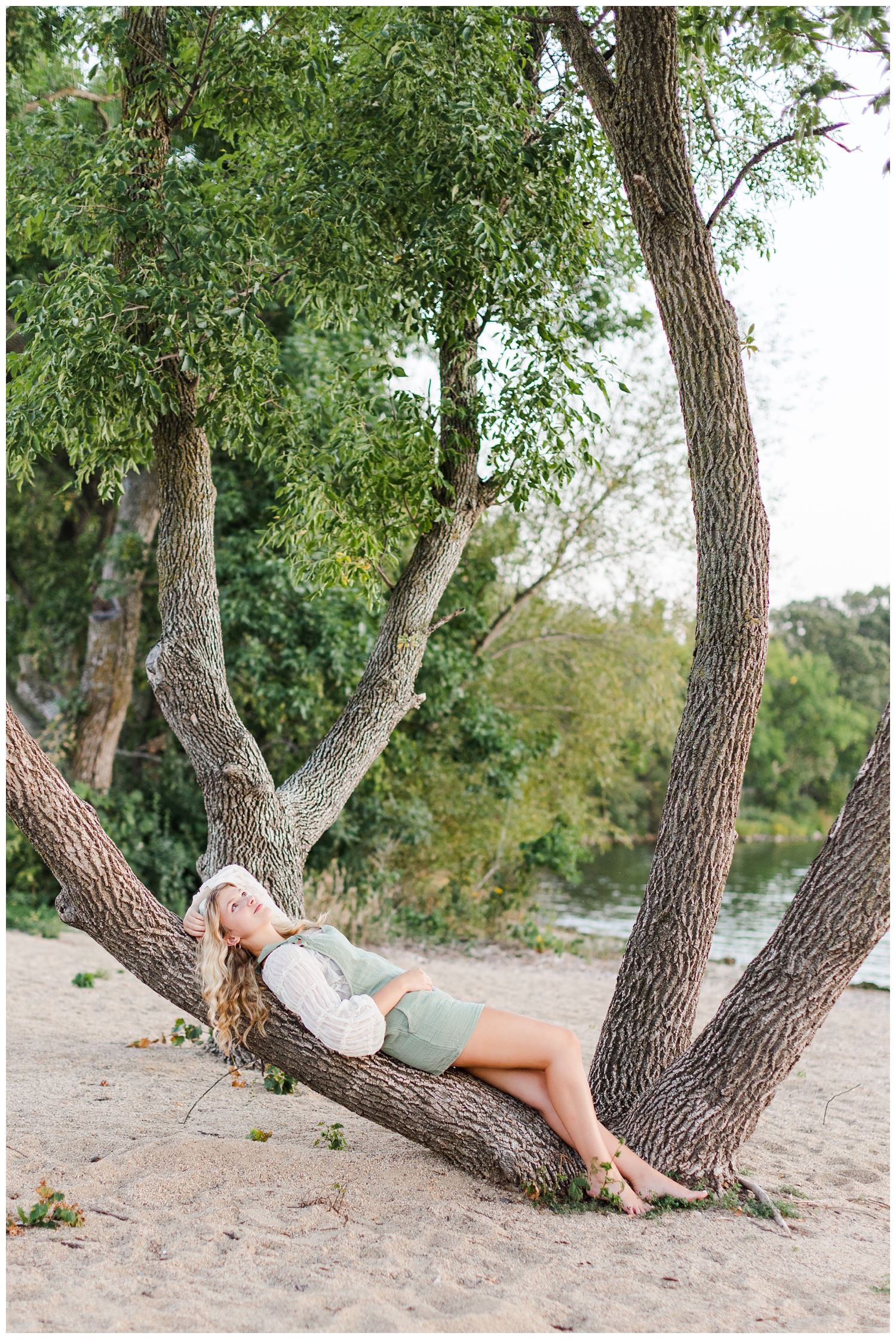 Rachel lays on a low tree branch at Lost Island | CB Studio