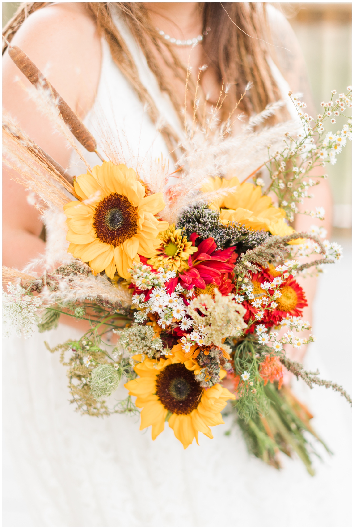 Loose gathered fall bridal bouquet consisting of sunflowers, Queen Anne's lace, cat tails, pampas grass, mums and other various home grown native Iowa florals | CB Studio
