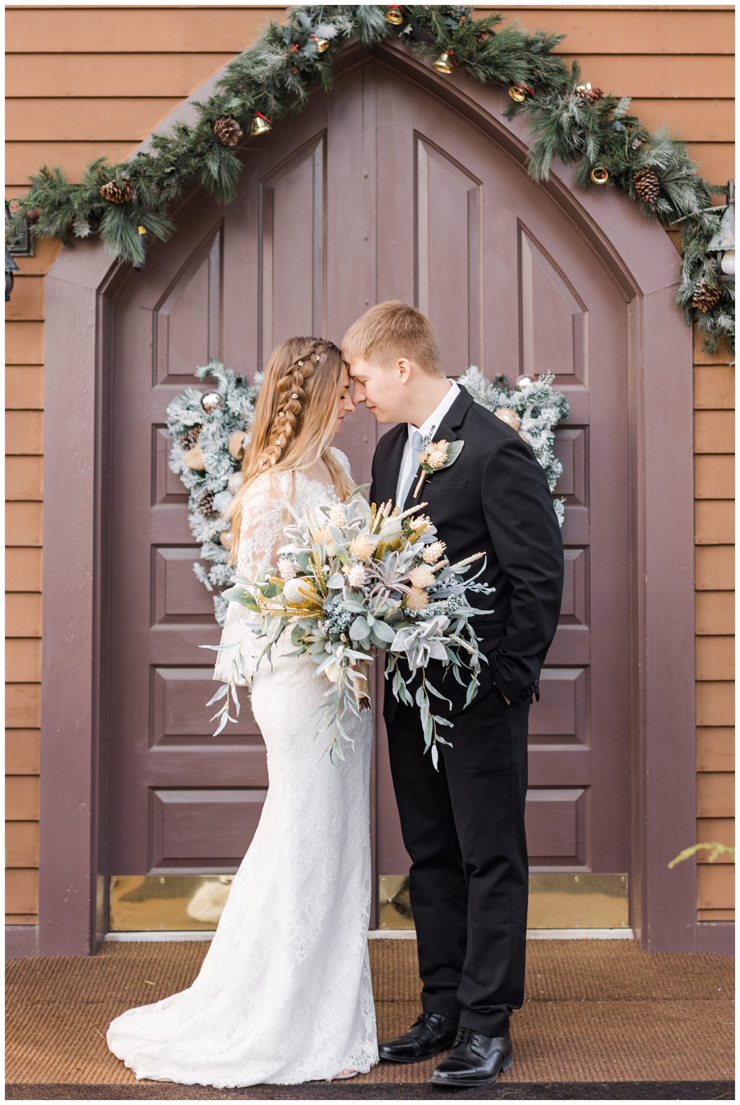 Bride and groom embrace in front of The Little Brown Church in the Vale in Nashua, IA | CB Studio